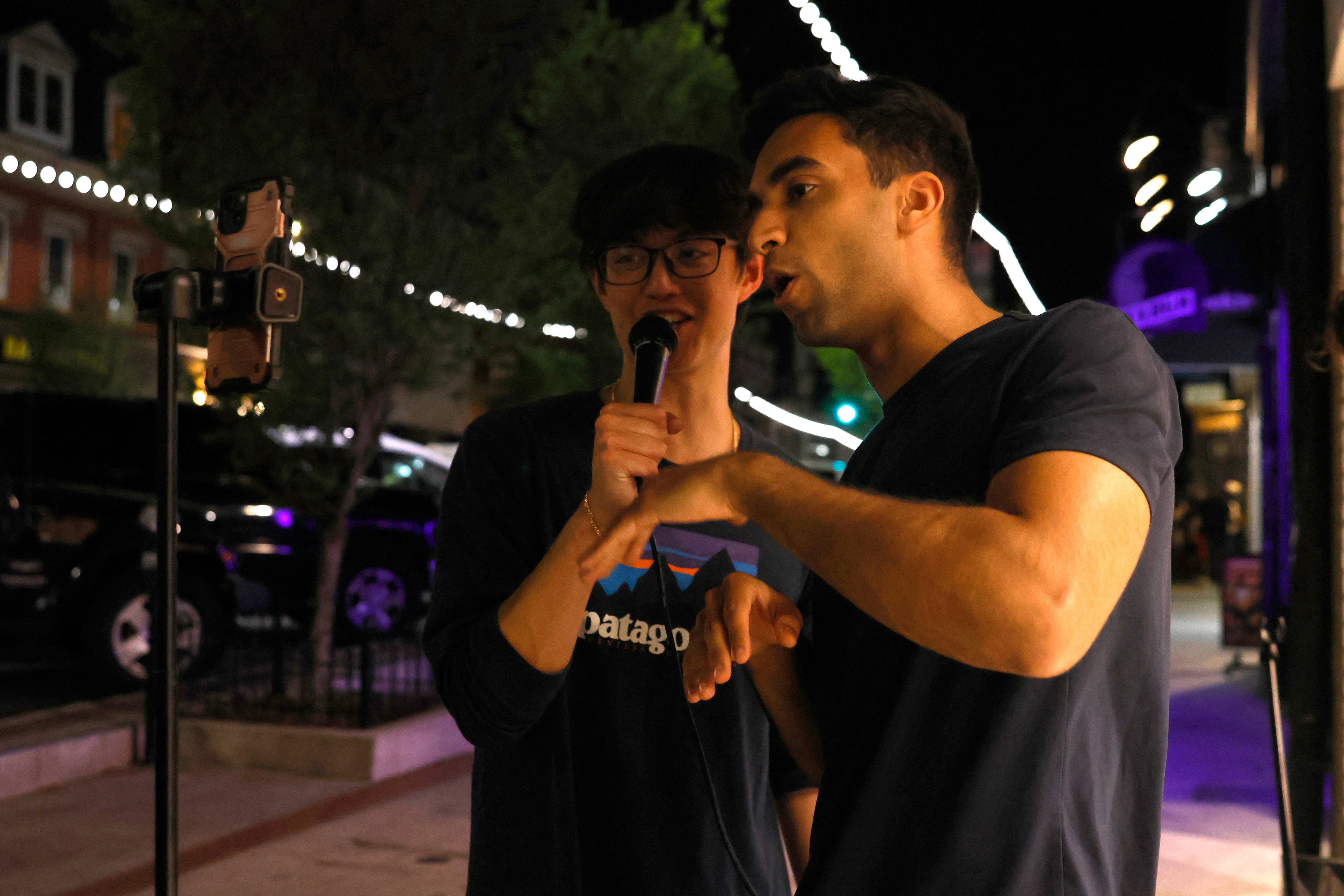 Andrew Hsu and a man sing together in front of Hsu's TikTok live in Athens, Georgia, on Friday, April 4, 2025. Hsu livestreams all of his performances on TikTok.
