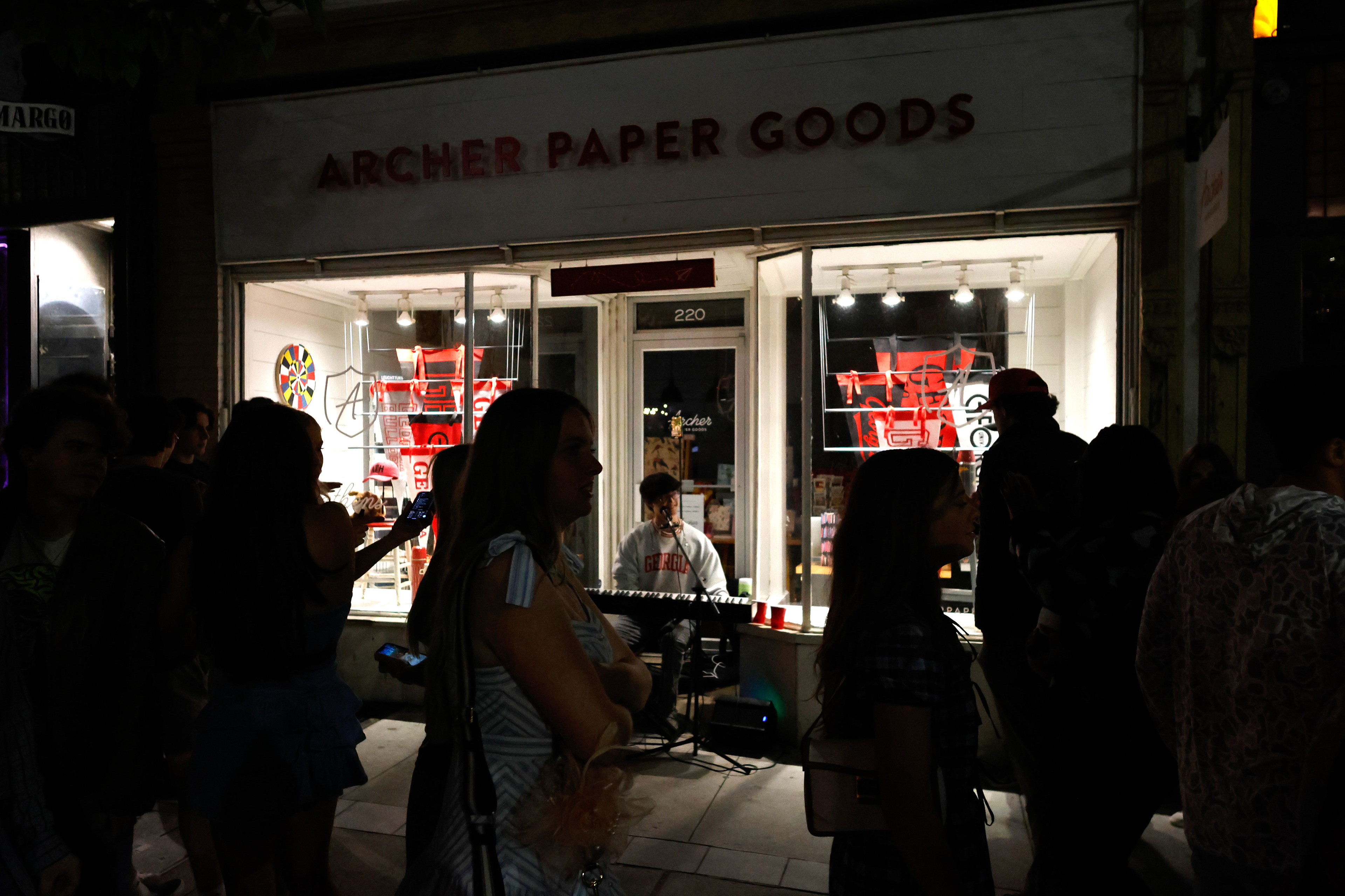 Andrew Hsu plays the piano as people walk by in downtown Athens, Georgia, on Friday, April 11, 2025. Hsu always performs in the doorway of Archer Paper Goods.