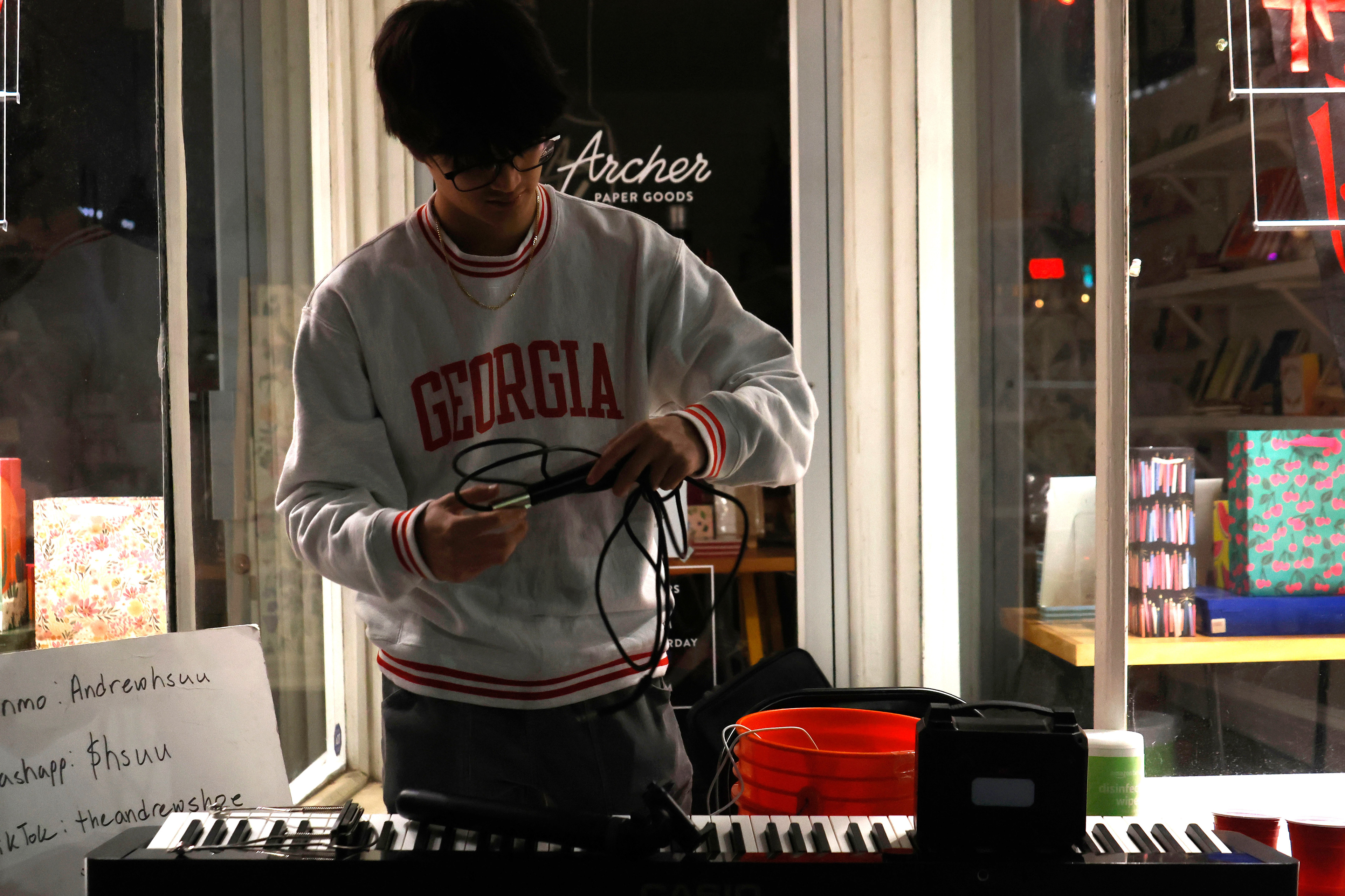 Andrew Hsu sets up his street music equipment on Friday, April 11, 2025. Hsu always performs in front of Archer Paper Goods.