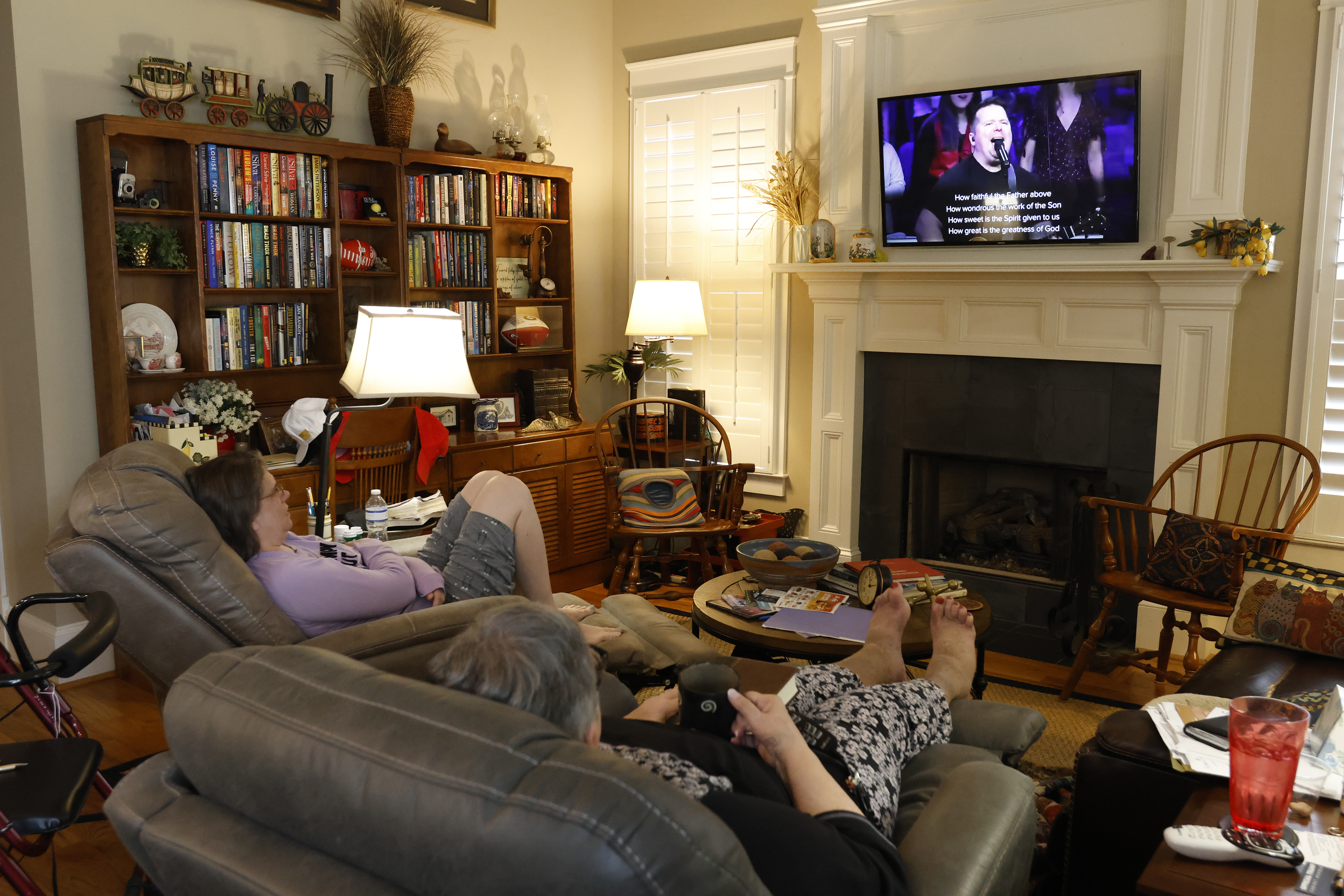 Cindi Weatherly and Aimee Ballentine watch Beech Haven Church's livestream service in their living room in Watkinsville, Georgia, on Sunday, February 9, 2025. They are unable to attend church in person due to Weatherly's health issues, but watch the service from home every week. 