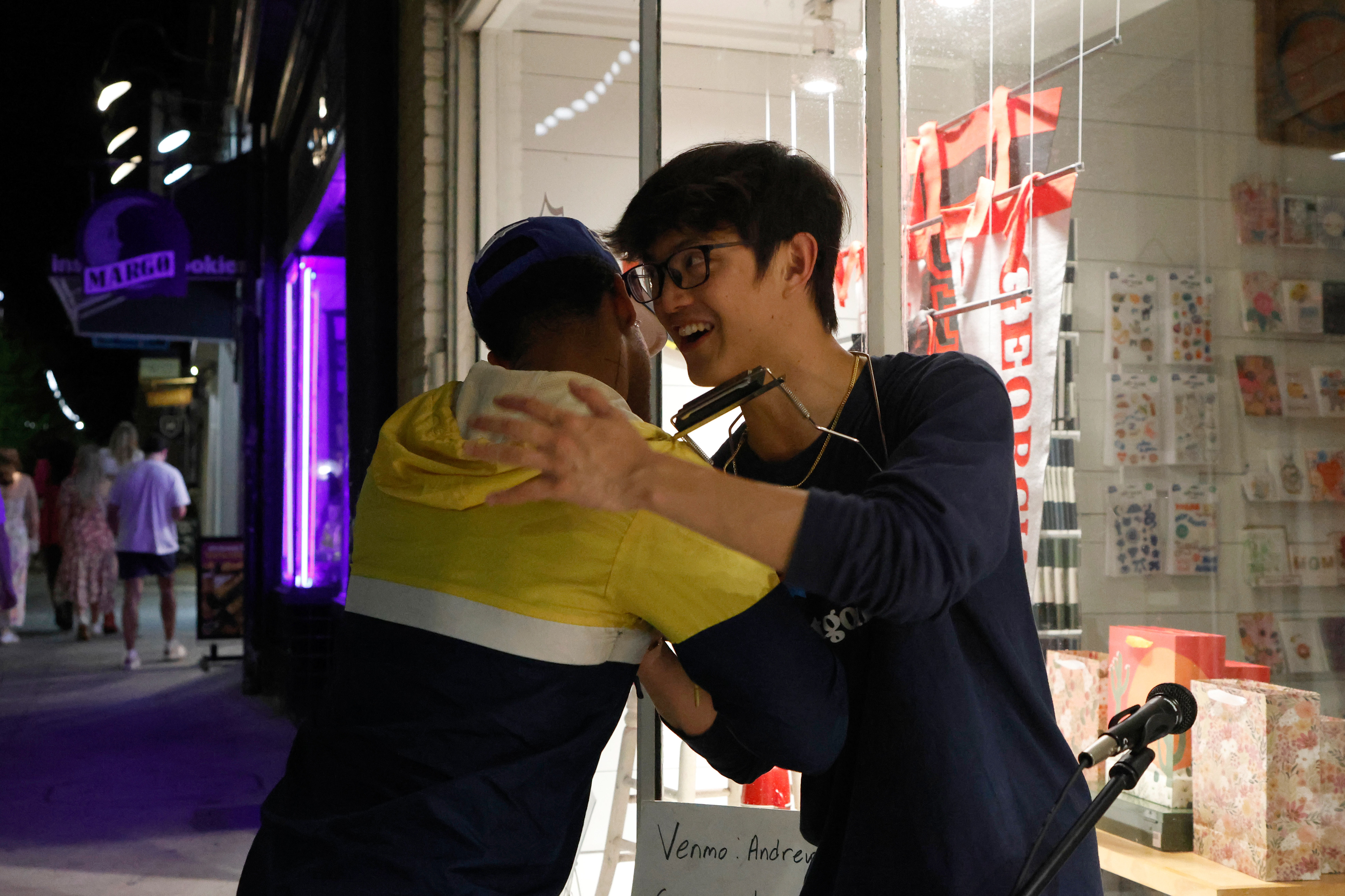 Andrew Hsu hugs someone who tipped him while he was street performing in downtown Athens, Georgia, on Thursday, April 3, 2025. Hsu says that he has met lots of interesting people through street performing.