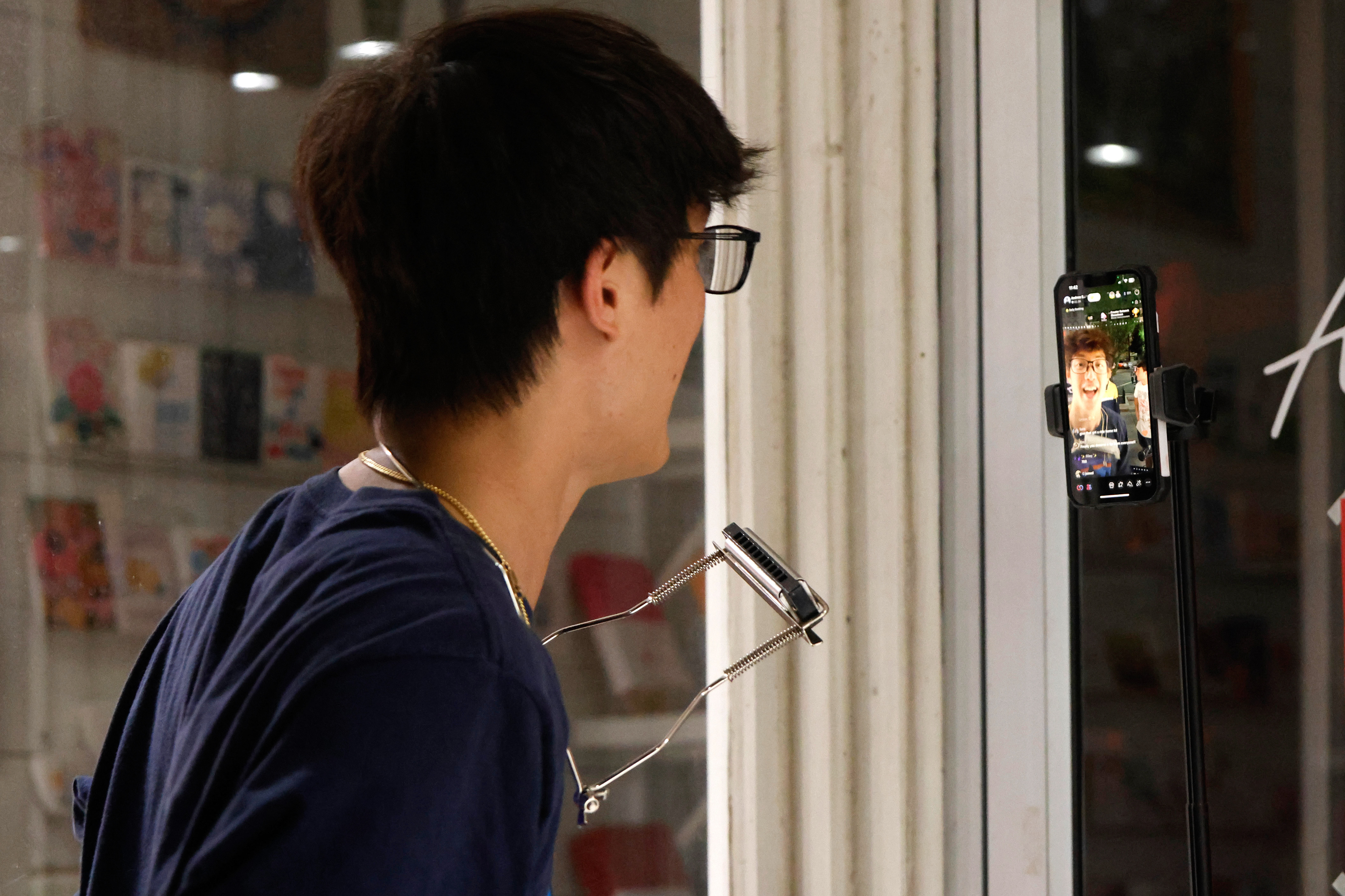Andrew Hsu talks to his TikTok livestream on Thursday, April 3, 2025, in Athens, Georgia. Hsu livestreams all of his street performances on TikTok.