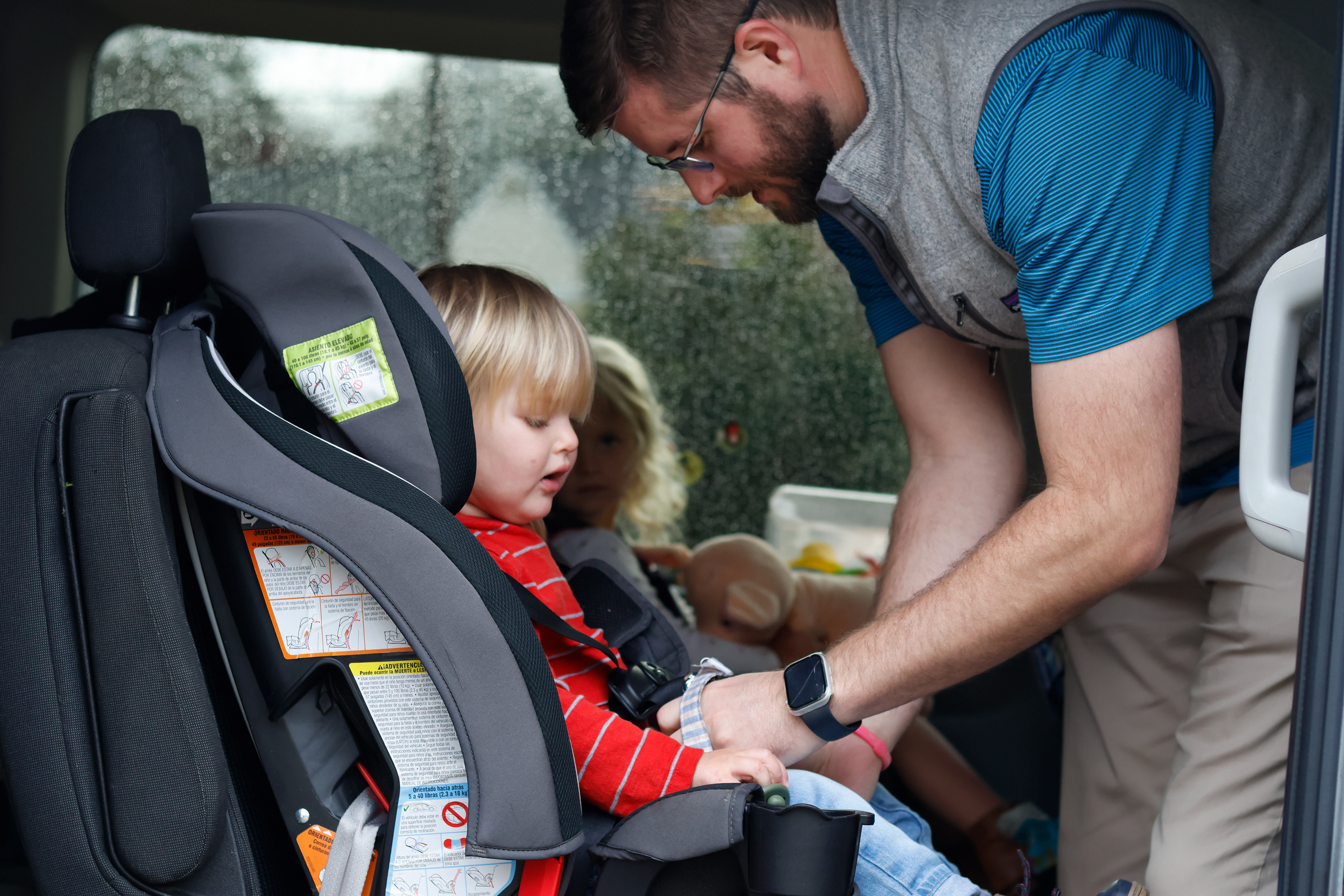 Daniel Crumbley buckles his son, Ezra Crumbley, into his car seat in their driveway in Athens, Georgia, on Sunday, February 16, 2025. The Crumbleys try to leave for church by 9 a.m. on Sundays.