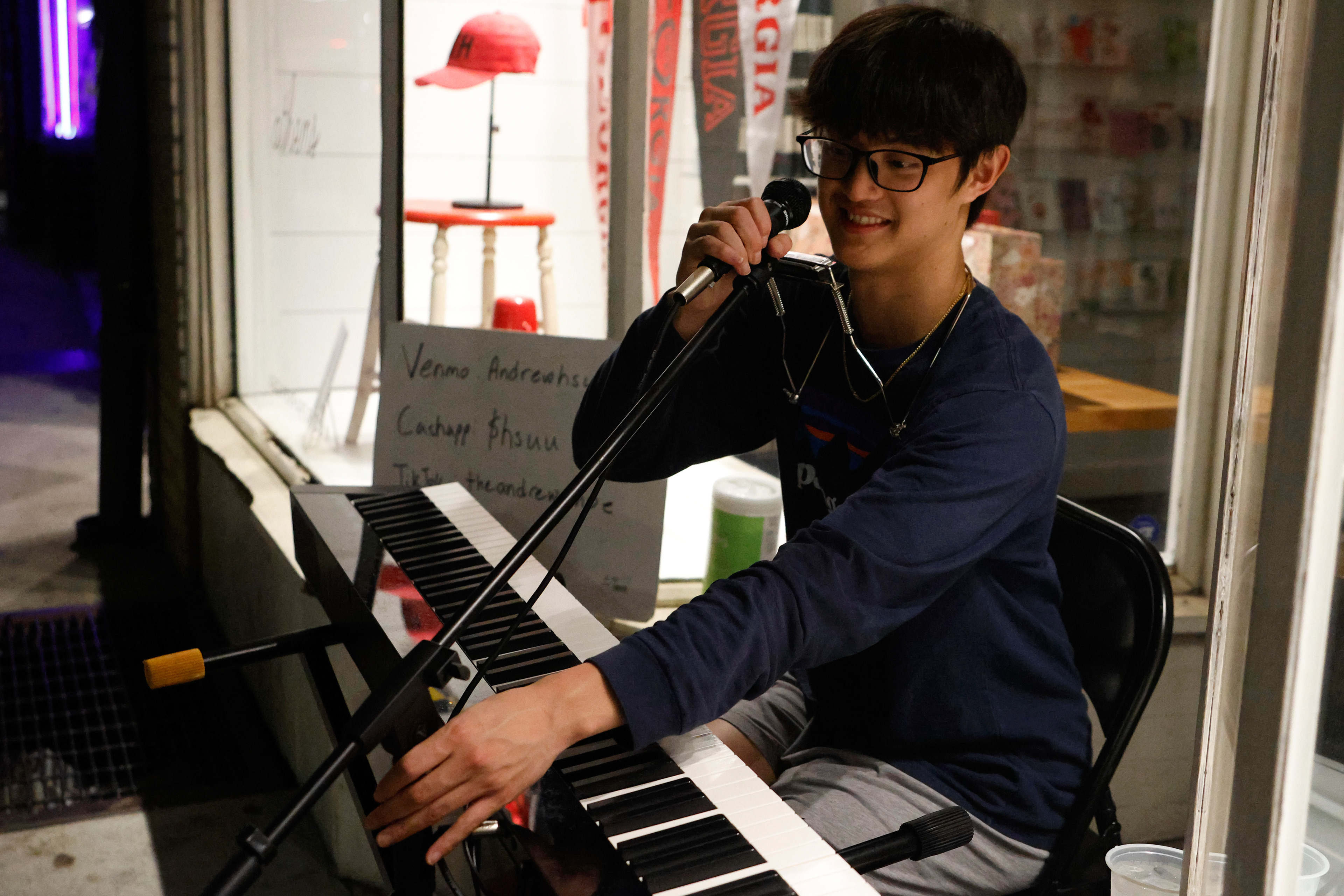 Andrew Hsu adjusts his microphone in downtown Athens, Georgia, on Thursday, April 3, 2025. Hsu began street performing in Athens during his sophomore year at the University of Georgia.
