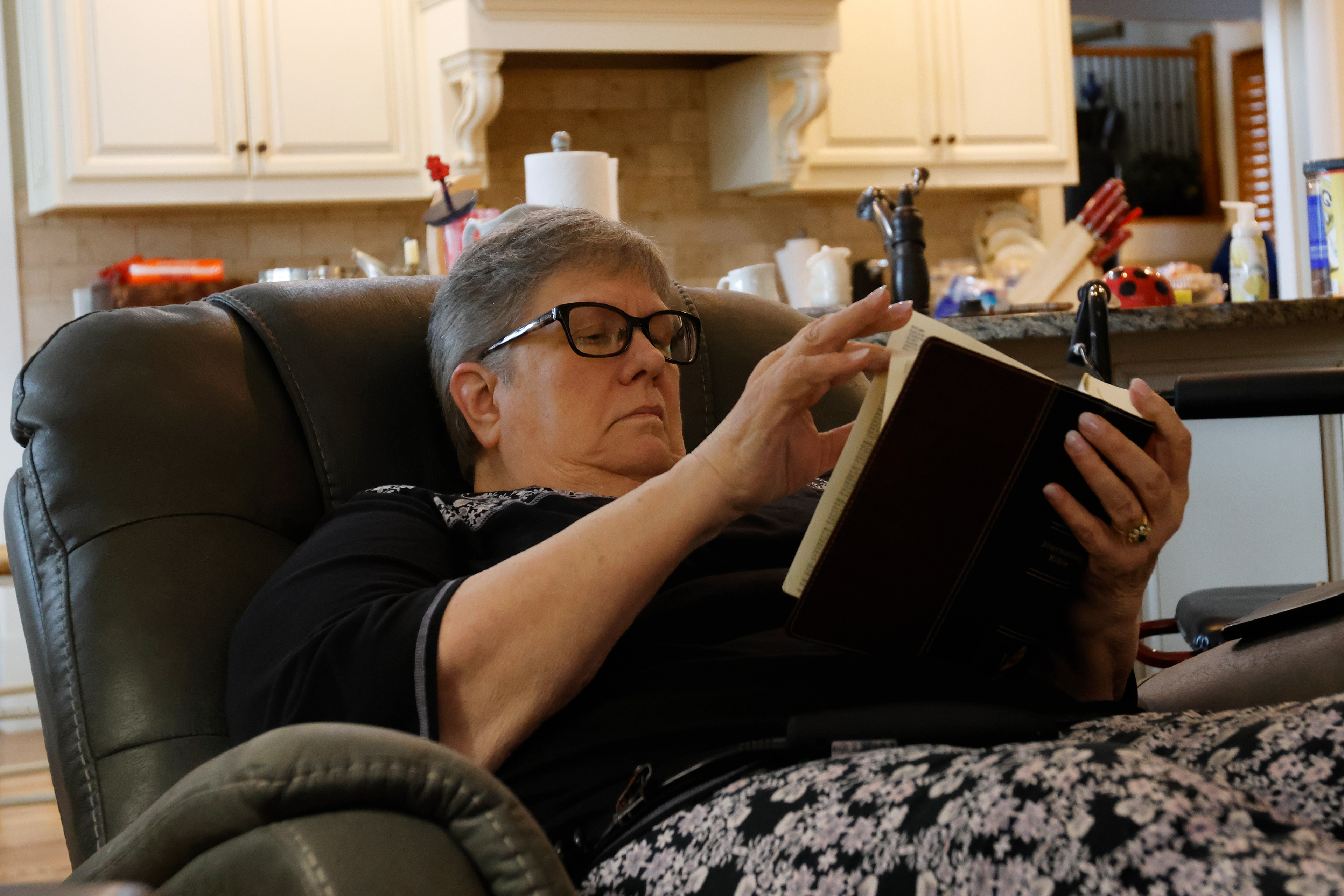 Cindi Weatherly reads her bible while watching Beech Haven Church's service livestream on Sunday, February 9, 2025, at her home in Watkinsville, Georgia. Weatherly is unable to attend church in person due to health issues, but watches the service from home every week.