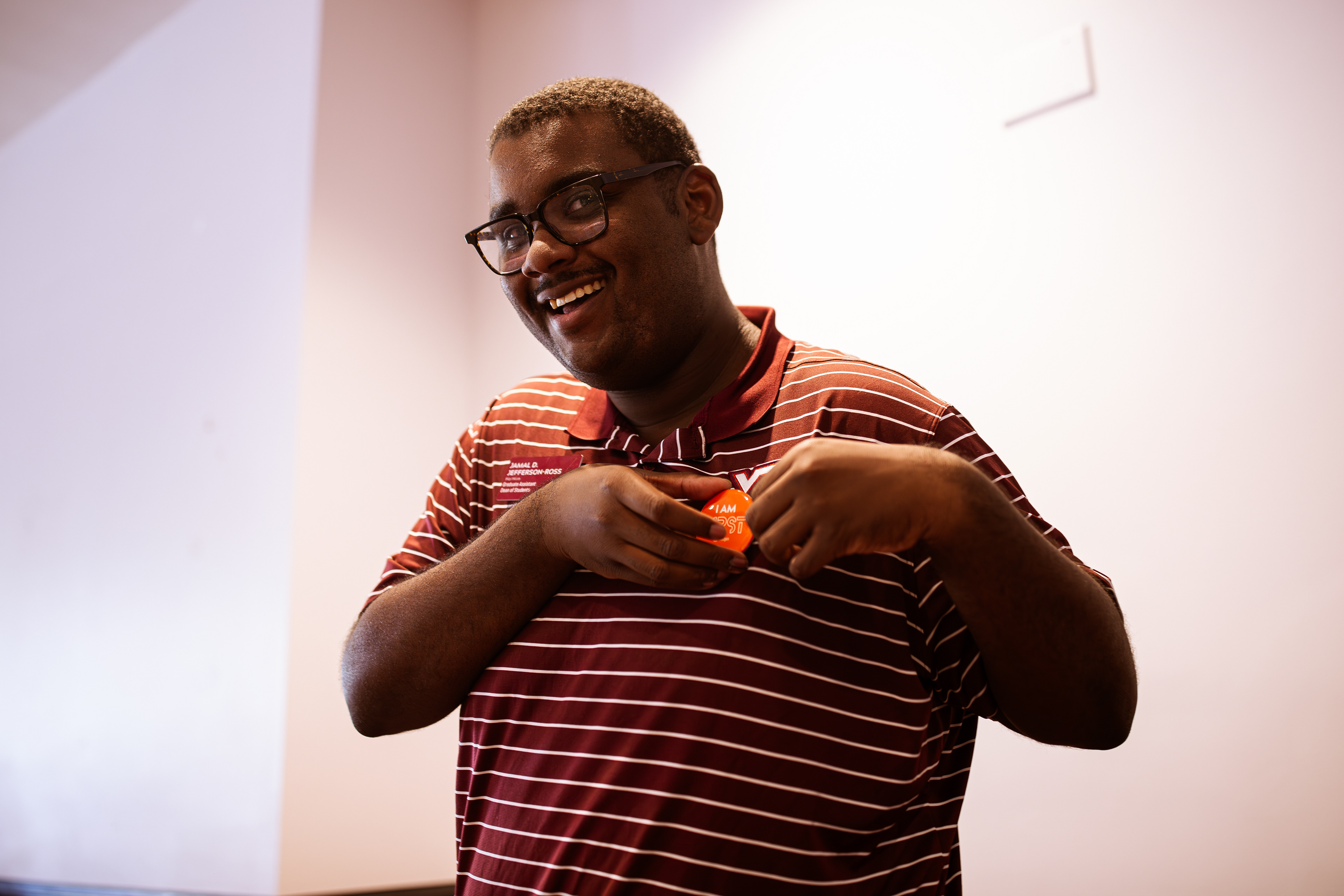 GenerationOne program mentor Jamal Jefferson-Ross attaches an “I am 1rst” button to his shirt on Monday, Oct. 14, 2024. (Thomas Bray/JMC 4114)