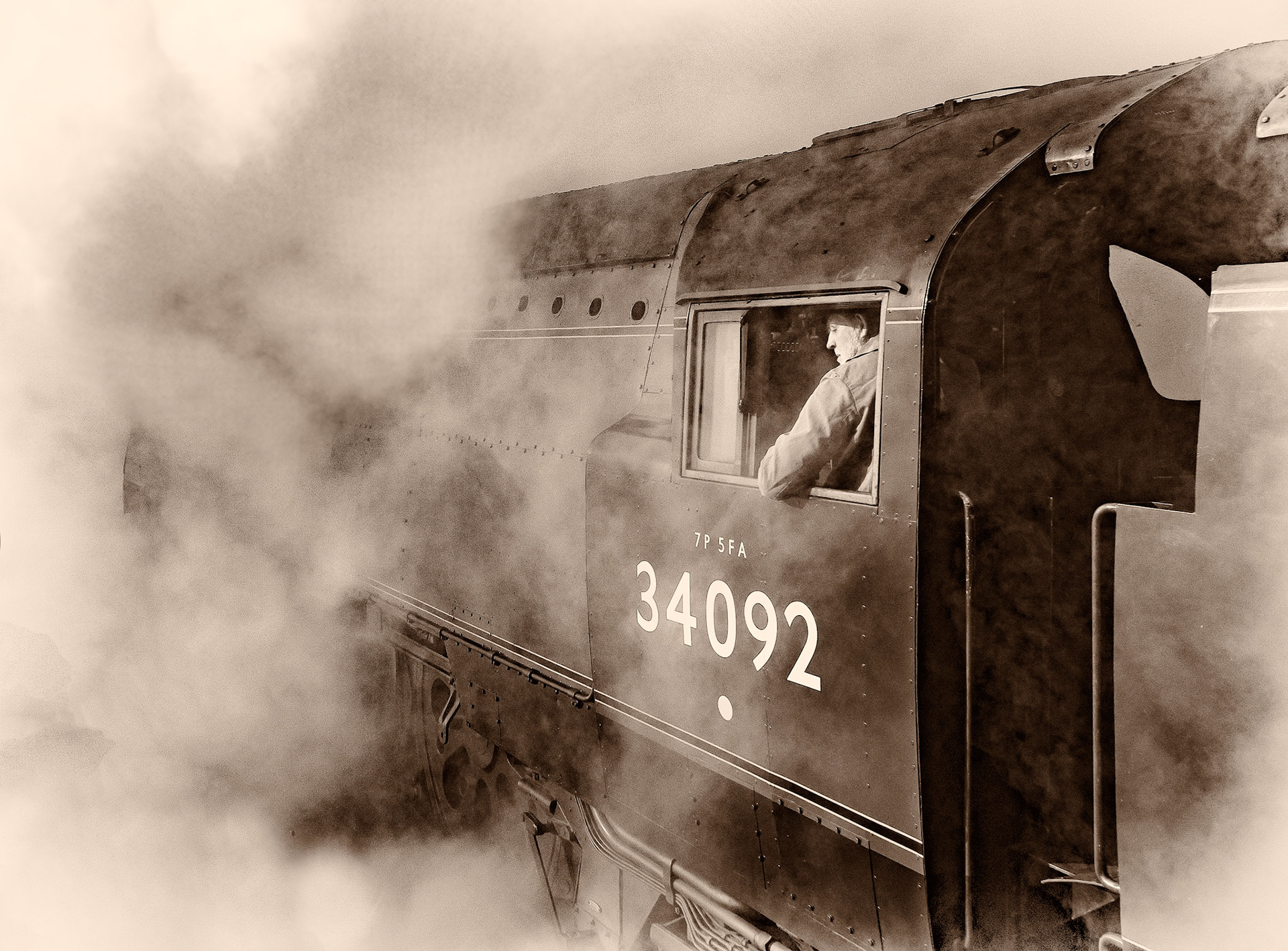 West country class steam locomotive 'City of Wells' engulfed in steam as it approaches Grosmont tunnel on the North Yorkshire Moors Railway, reproduced here in a sepia effect.