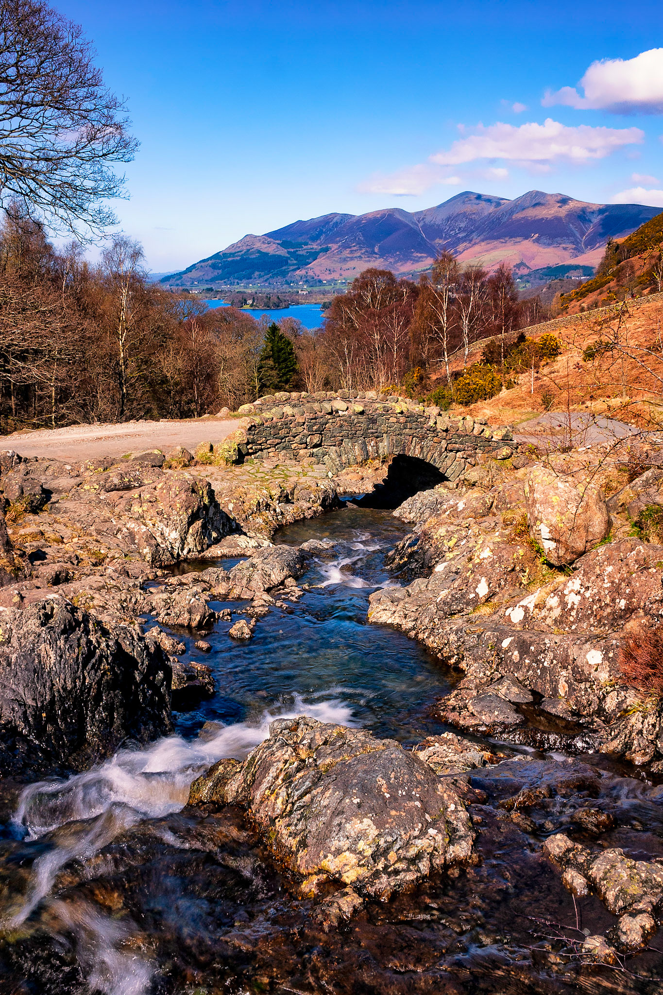 Ashness Bridge in the English Lake District with Derwentwater, Keswick and the mountain of Skiddaw in the background.