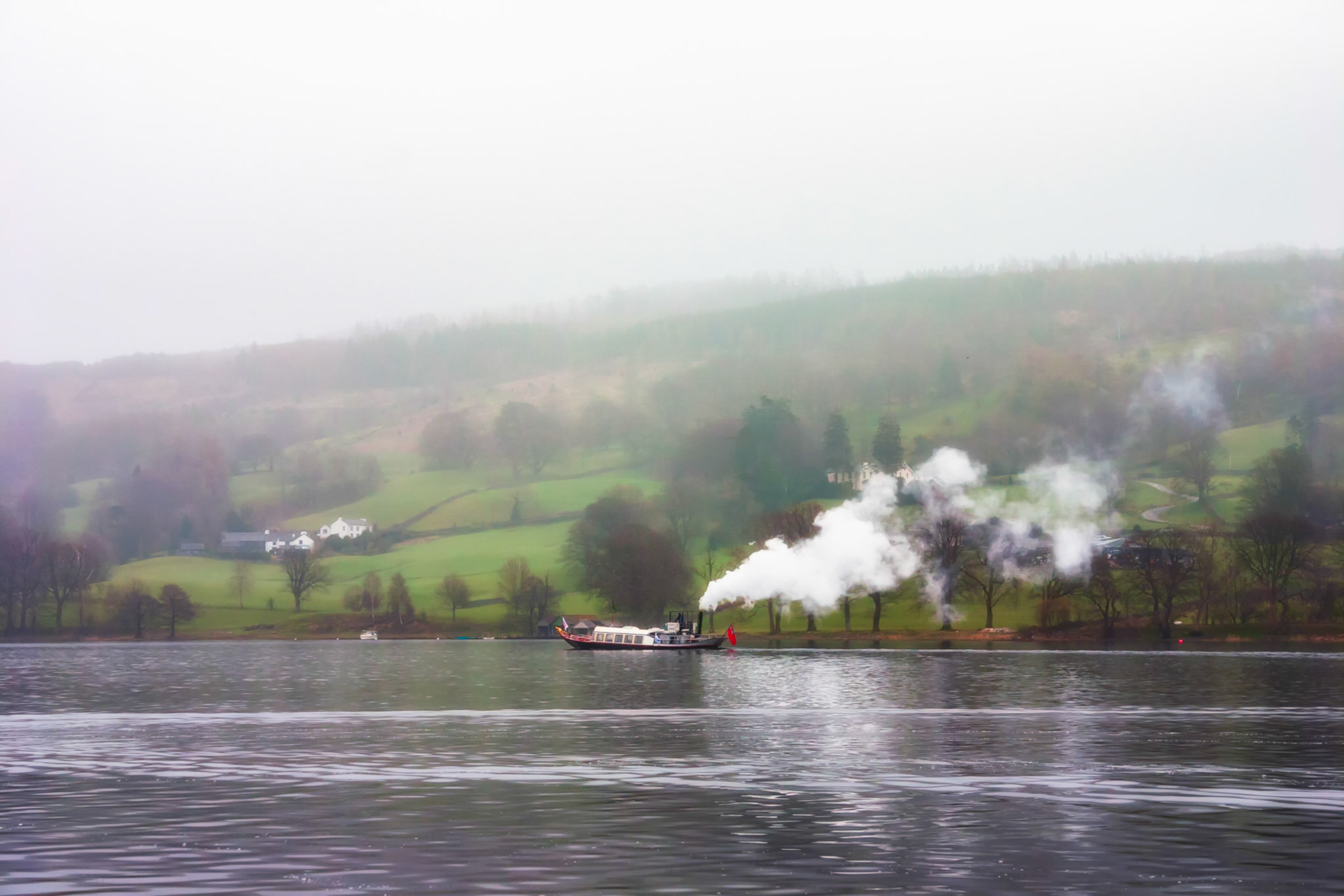 The steam ferry 'Gondola' winds its way away from the Lake Road jetty on Coniston lake the English Lake District on a typical misty lakeland winter's day. Launched in 1859 to serve the passengers of the then new Furness Railway.