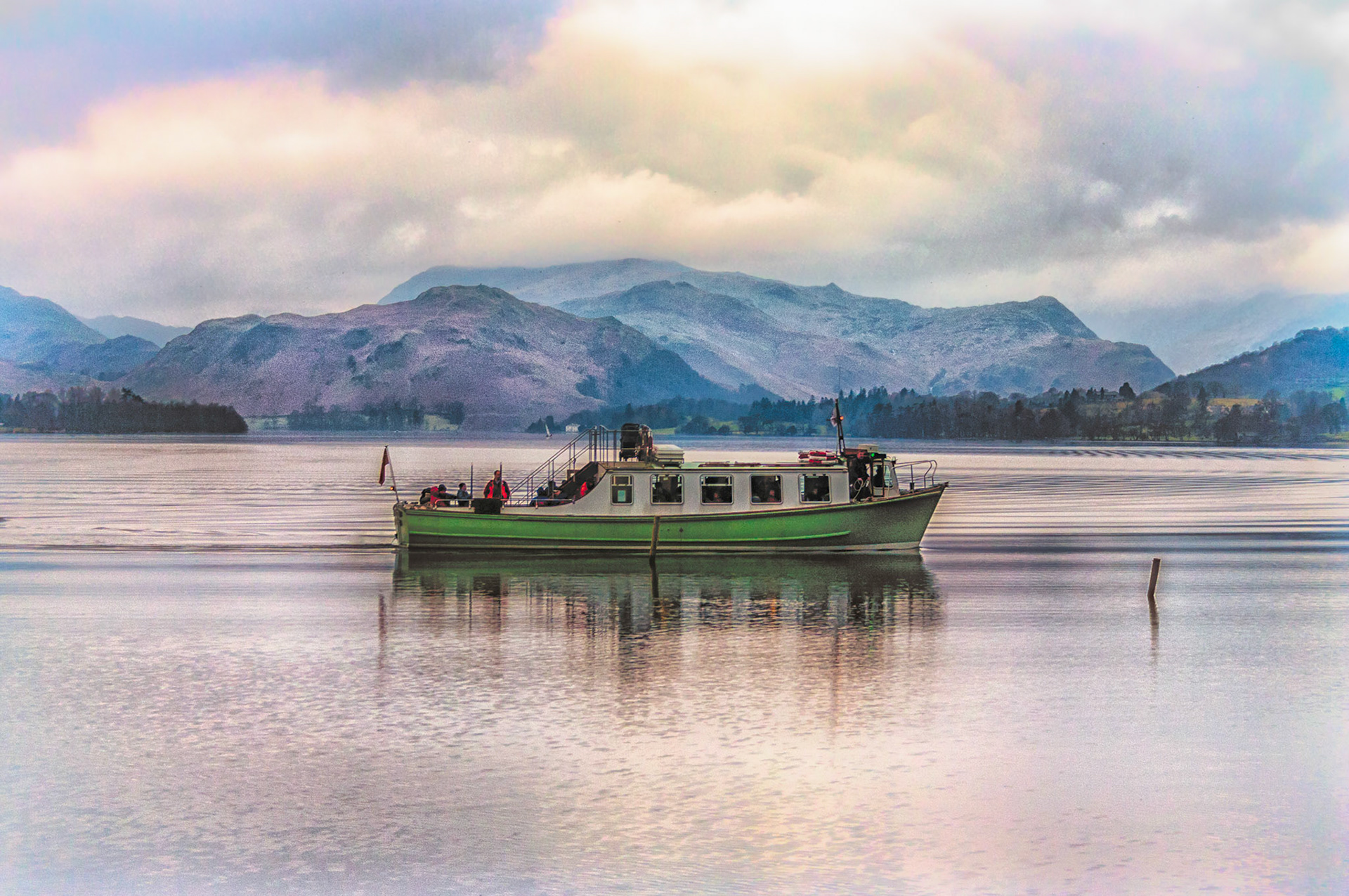 The Ullswater Ferry arriving at Pooley Bridge in the English Lakes District National Park on a typically still, calm and overcast winter morning. 