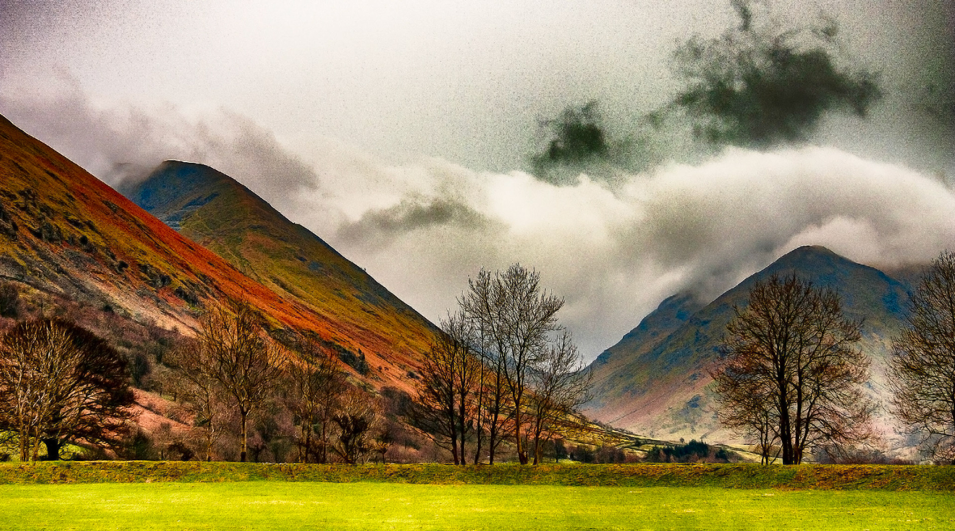 Low clouds roll over lake districts peaks.