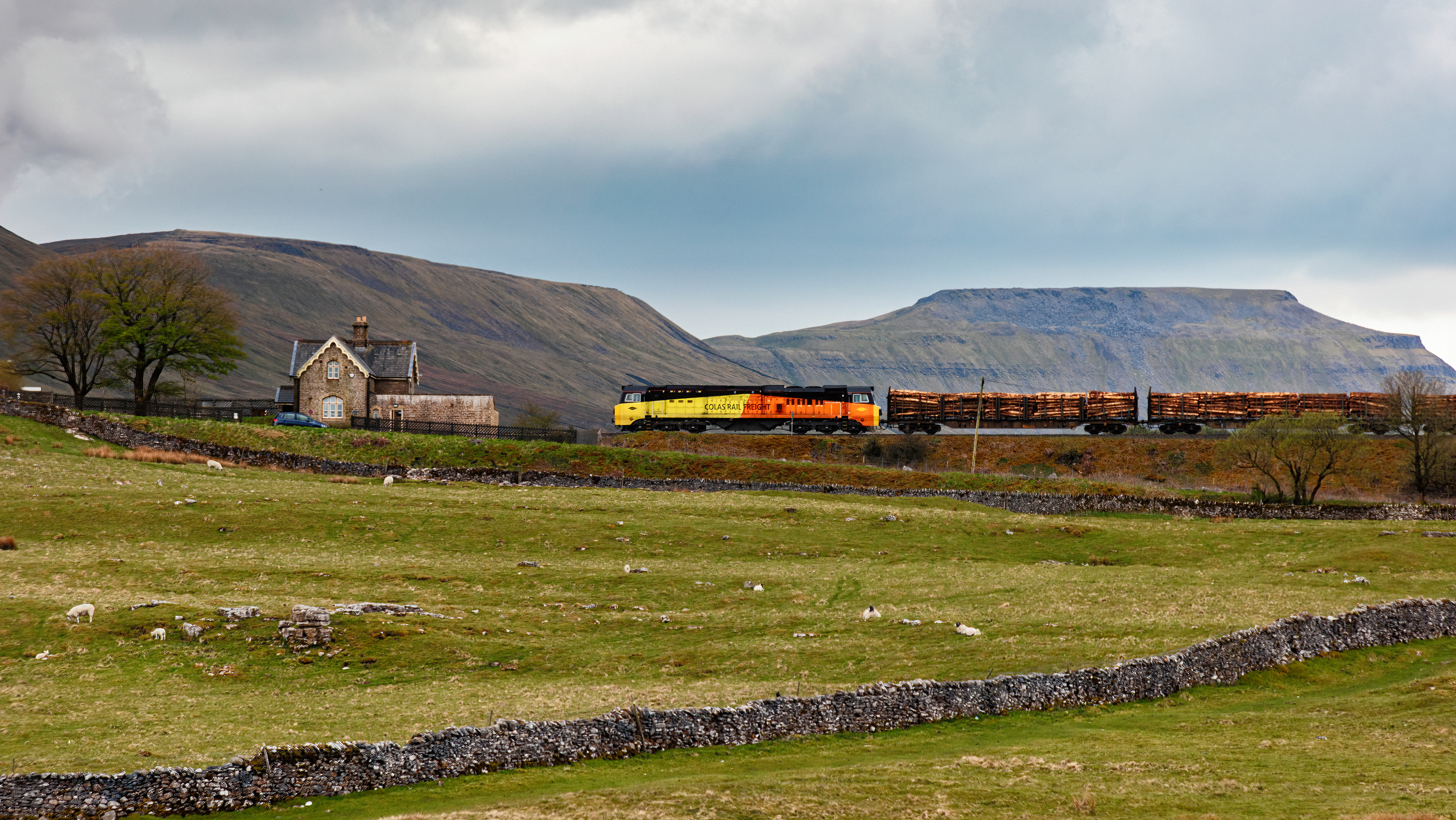 Colas Class 70 passing Ribblehead station with Ingleborough in the background