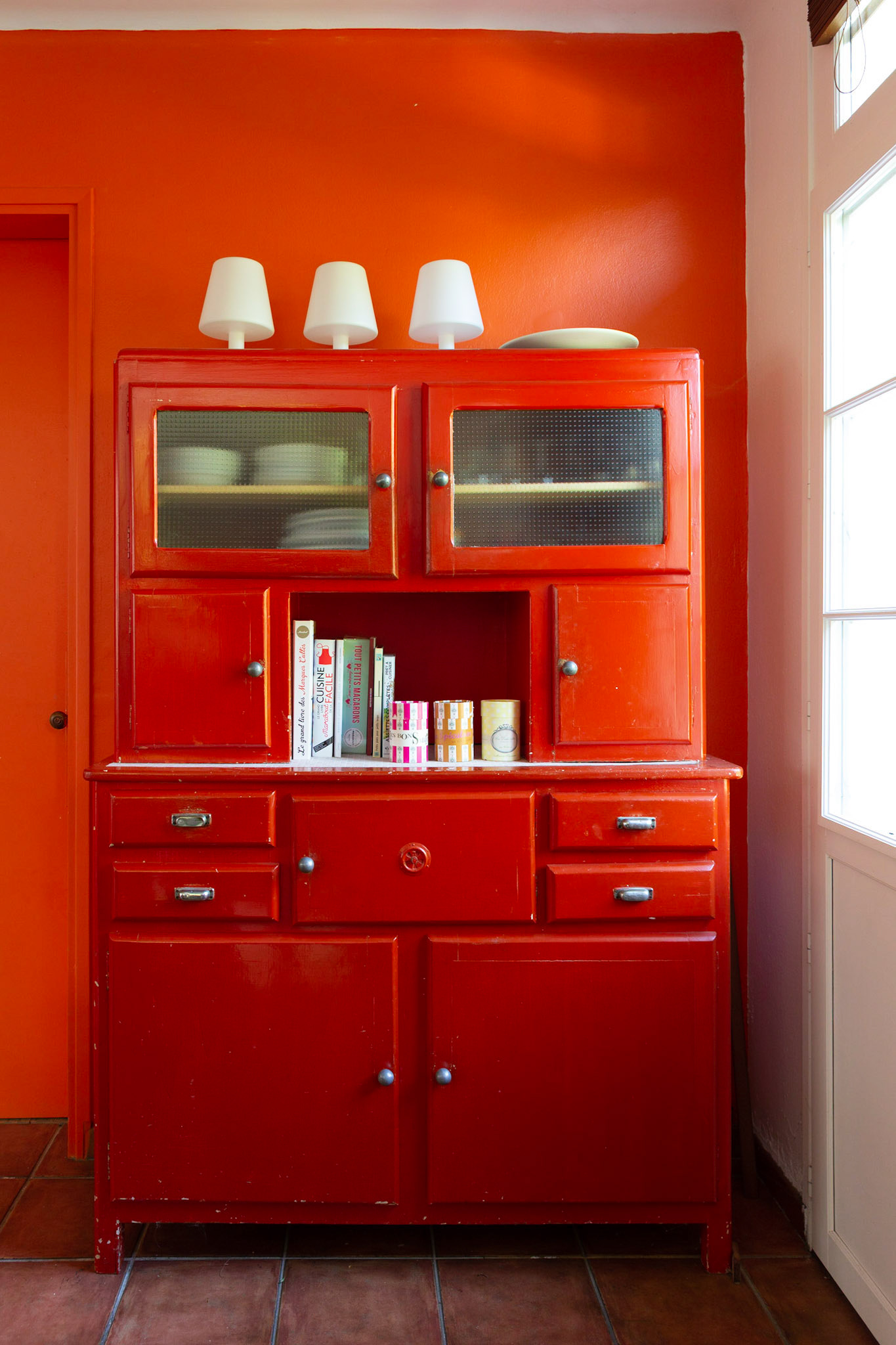 mur orange pour accueillir le vaisselier années 60 peint en rouge