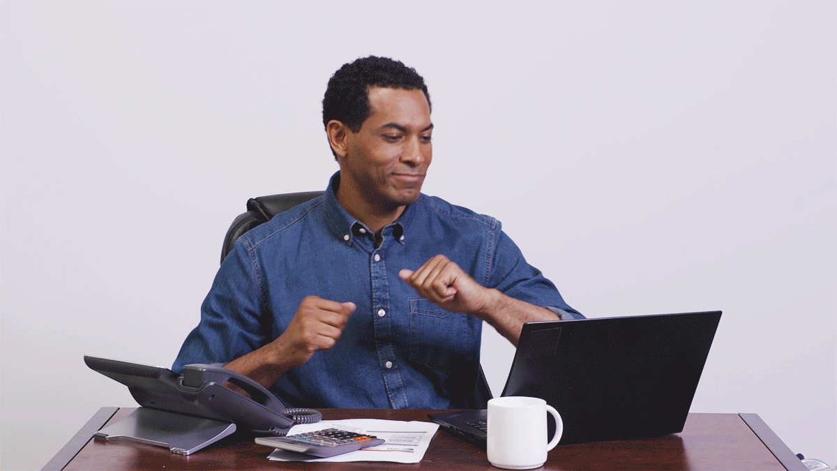 GIF of man happily dancing in front of desk