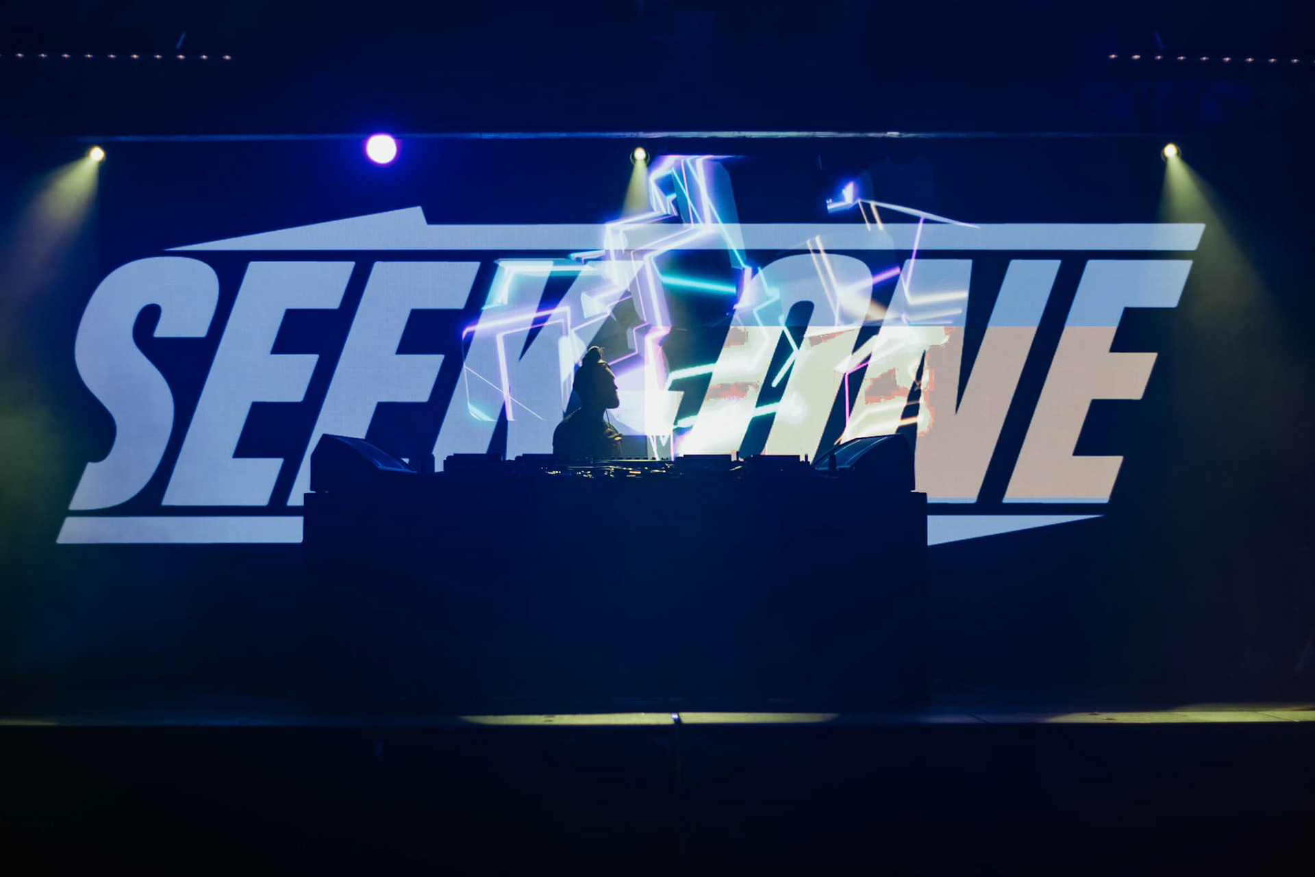 Seek-One DJing with logo stage visuals. 📸 Credit: Kristal Diaz