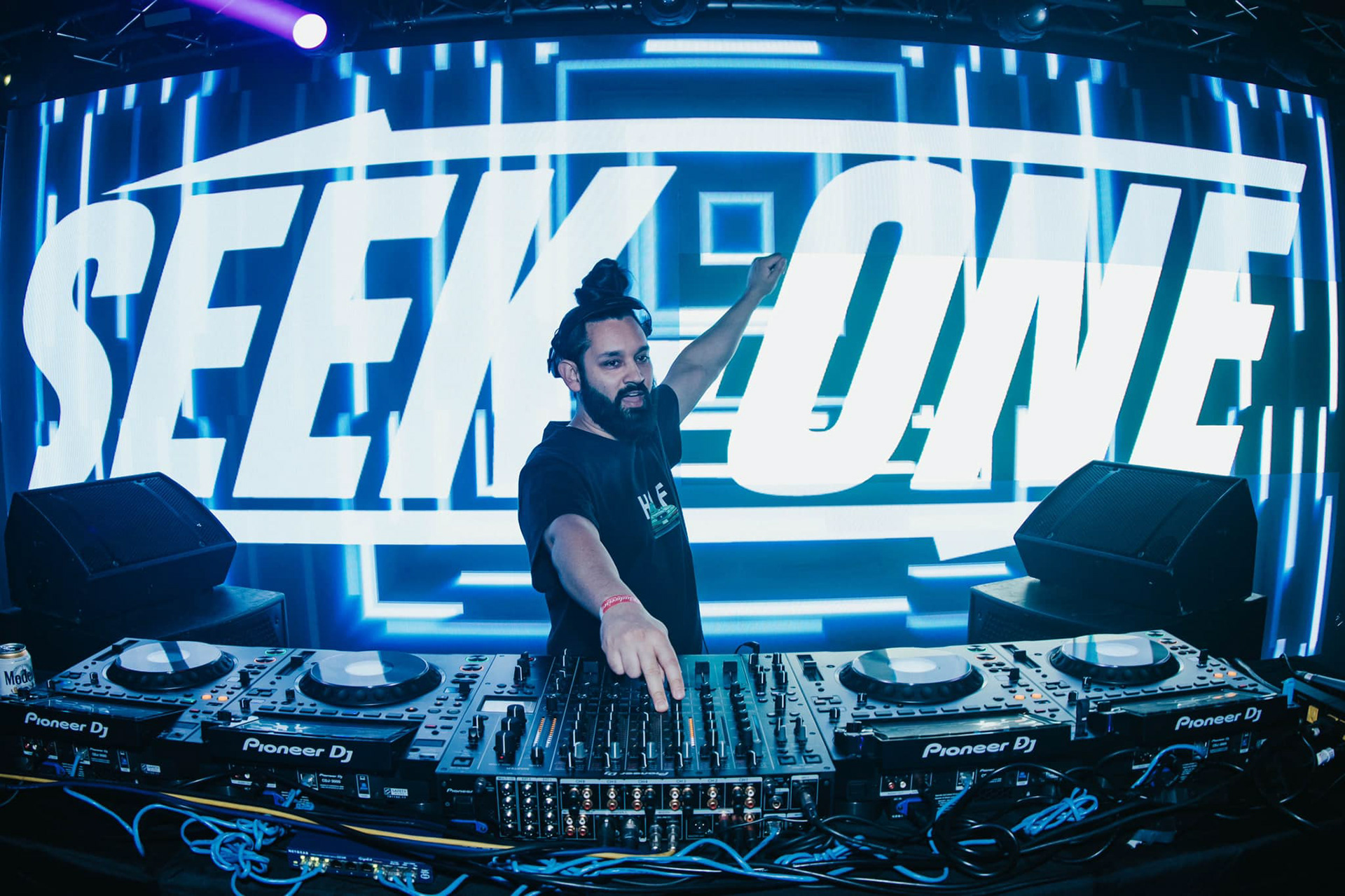 Seek-One DJing with logo stage visuals. 📸 Credit: Kristal Diaz