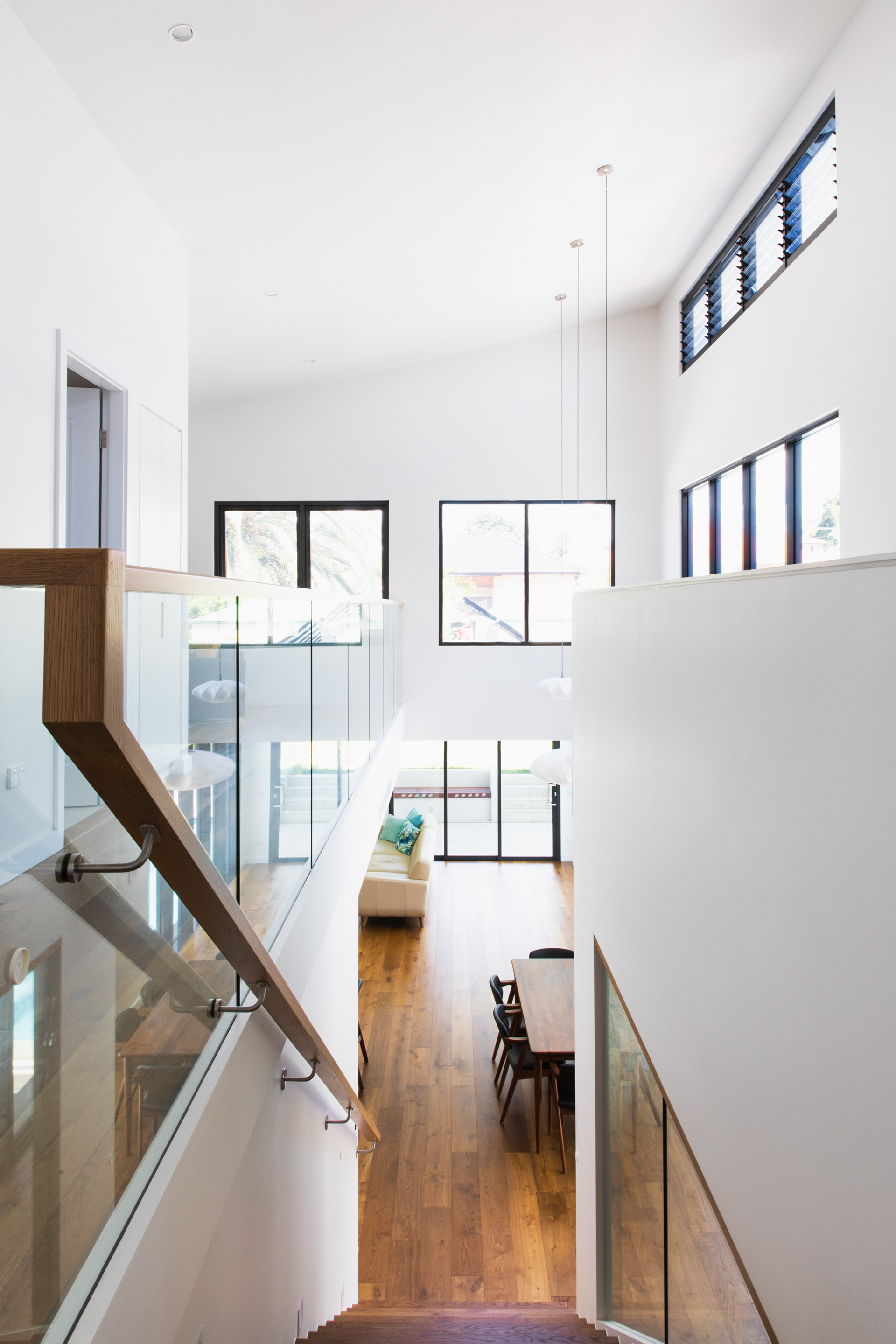 Raked ceiling, high clerestory windows orientated north dramatically infill natural light over the double height volume, new staircase, living and dining area.