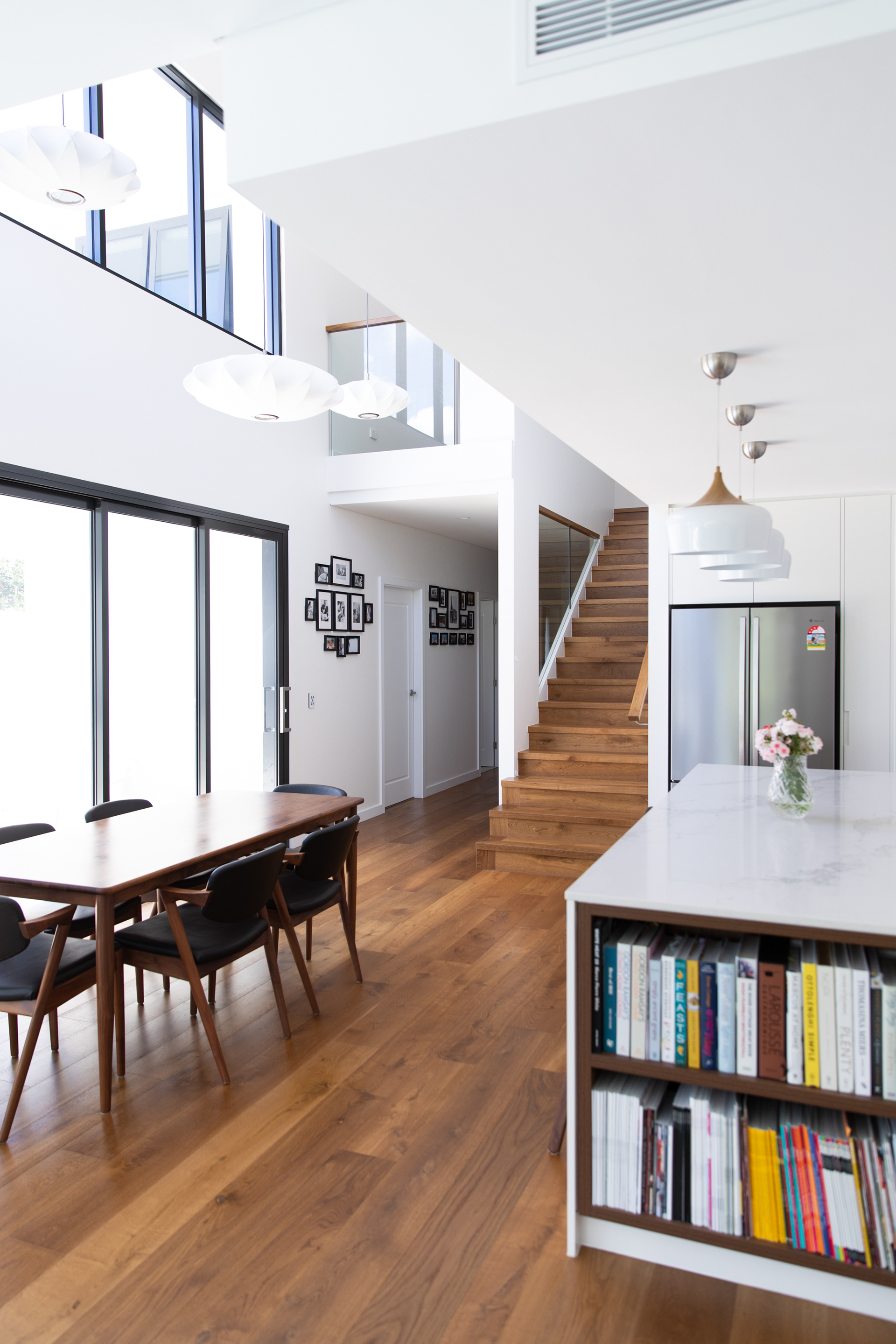 Light filled spills into central kitchen and dining area. The off-white interior is accentuated by the natural timber.