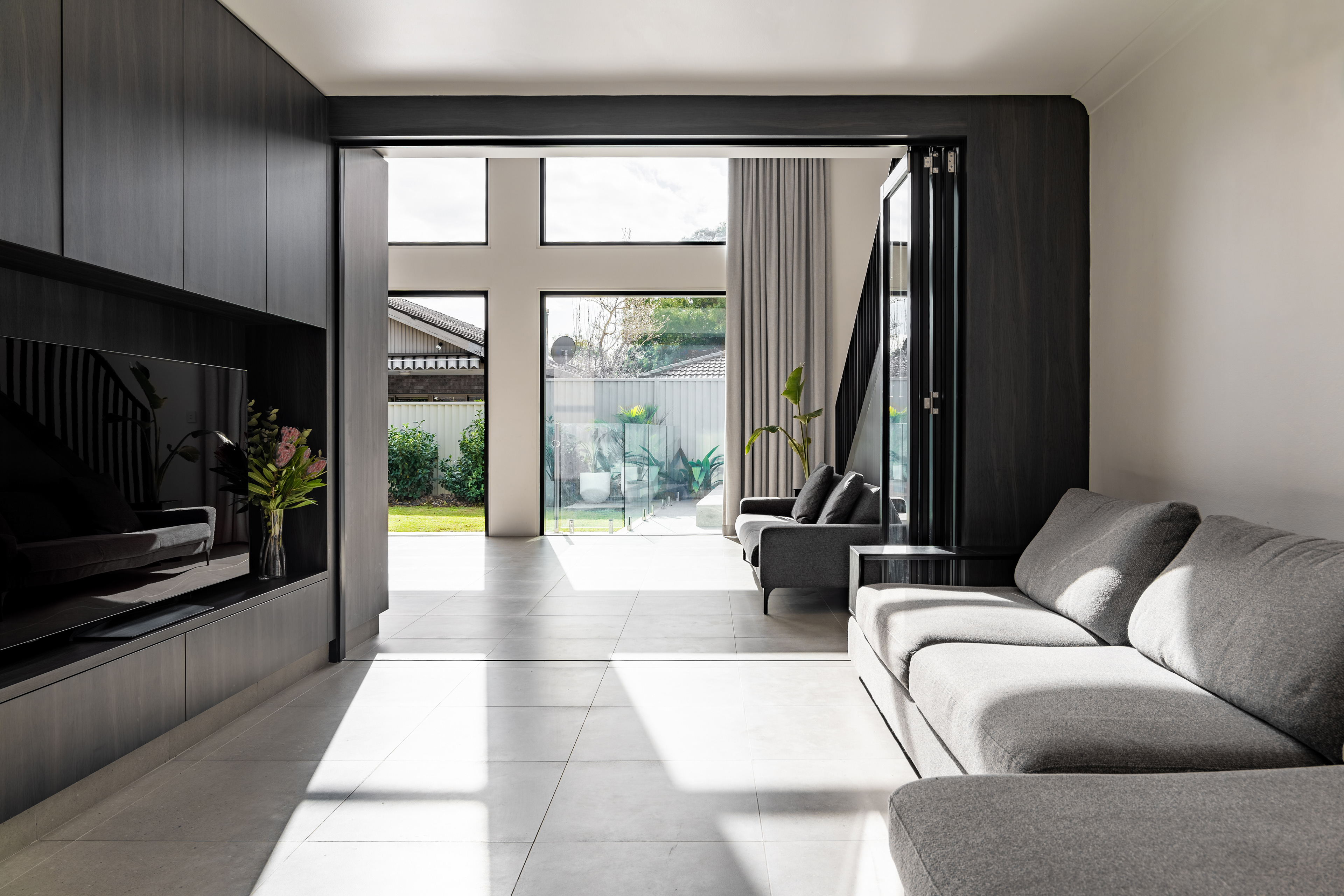 Integrated joinery between a living room and dining area that opens out to the garden.