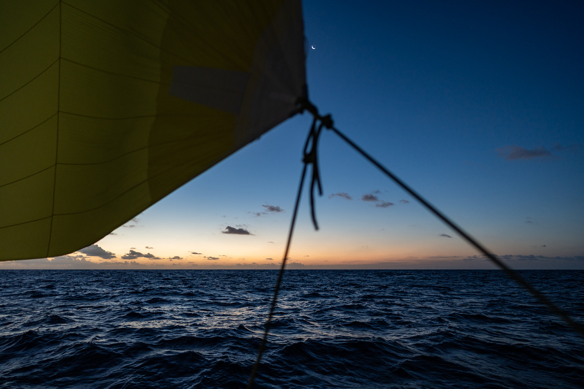 A sliver of the moon rises out beyond the fading light of dusk