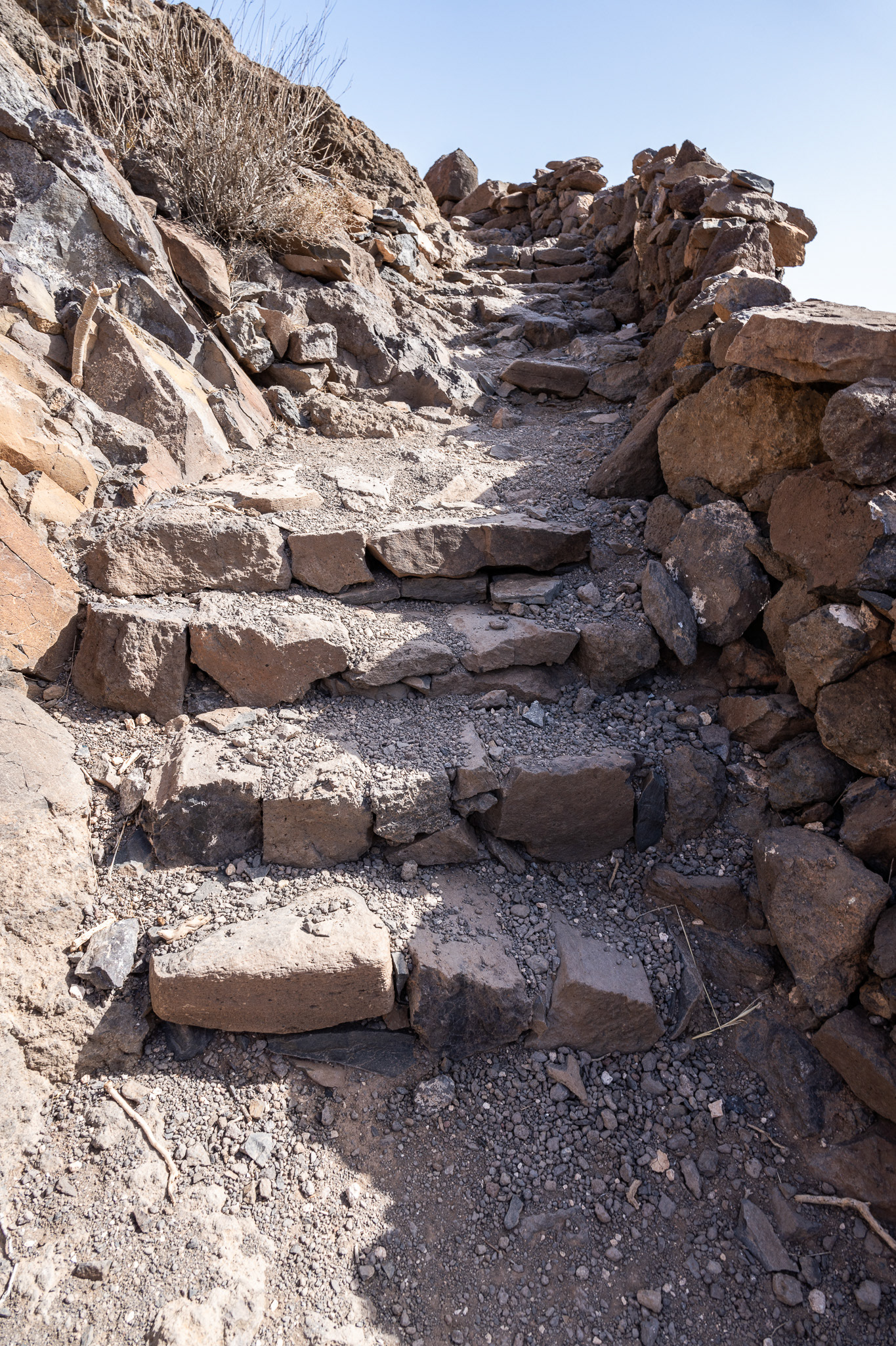 A collection of organized steps with a thin stone wall