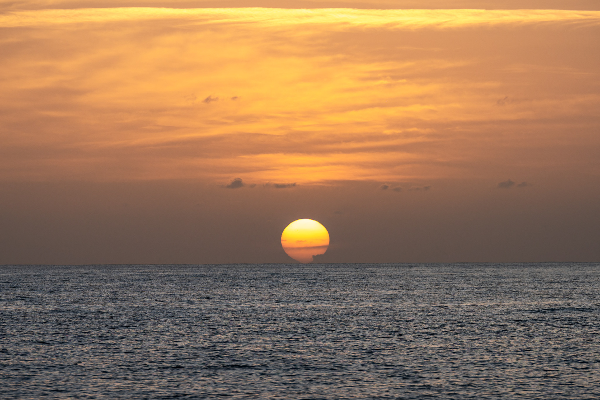 The horizon sucks the sun down below during another beautiful Barbadian evening