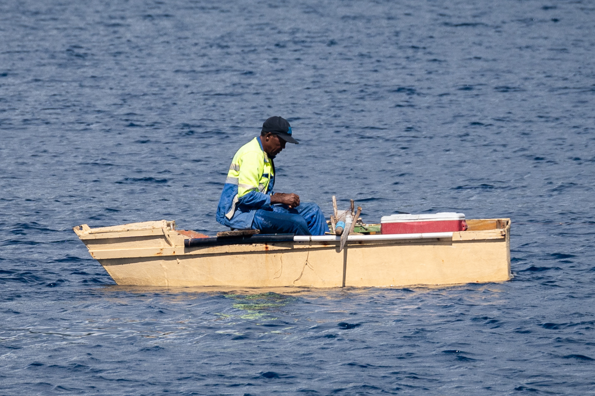 A local uses a handline to fish from his row boat