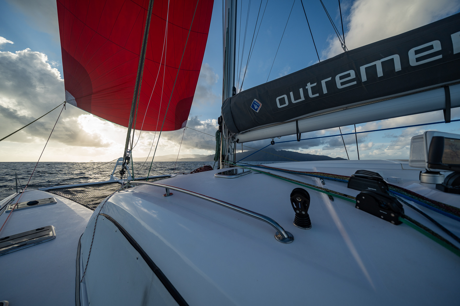 Powering down the coast of Ua Huka into the setting sun, under spinnaker