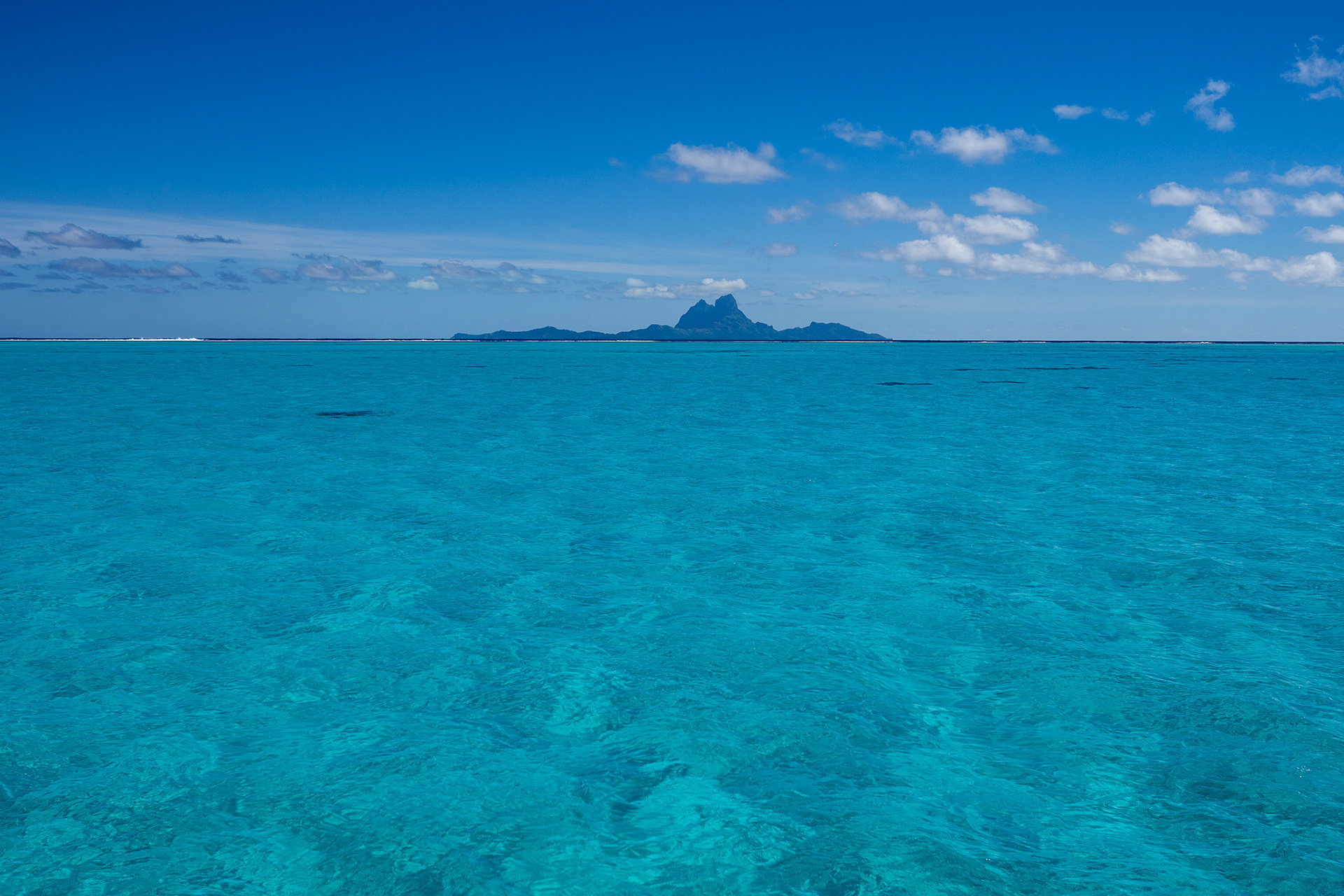 Crystal blue water spanning the lagoon, with Bora Bora as a backdrop