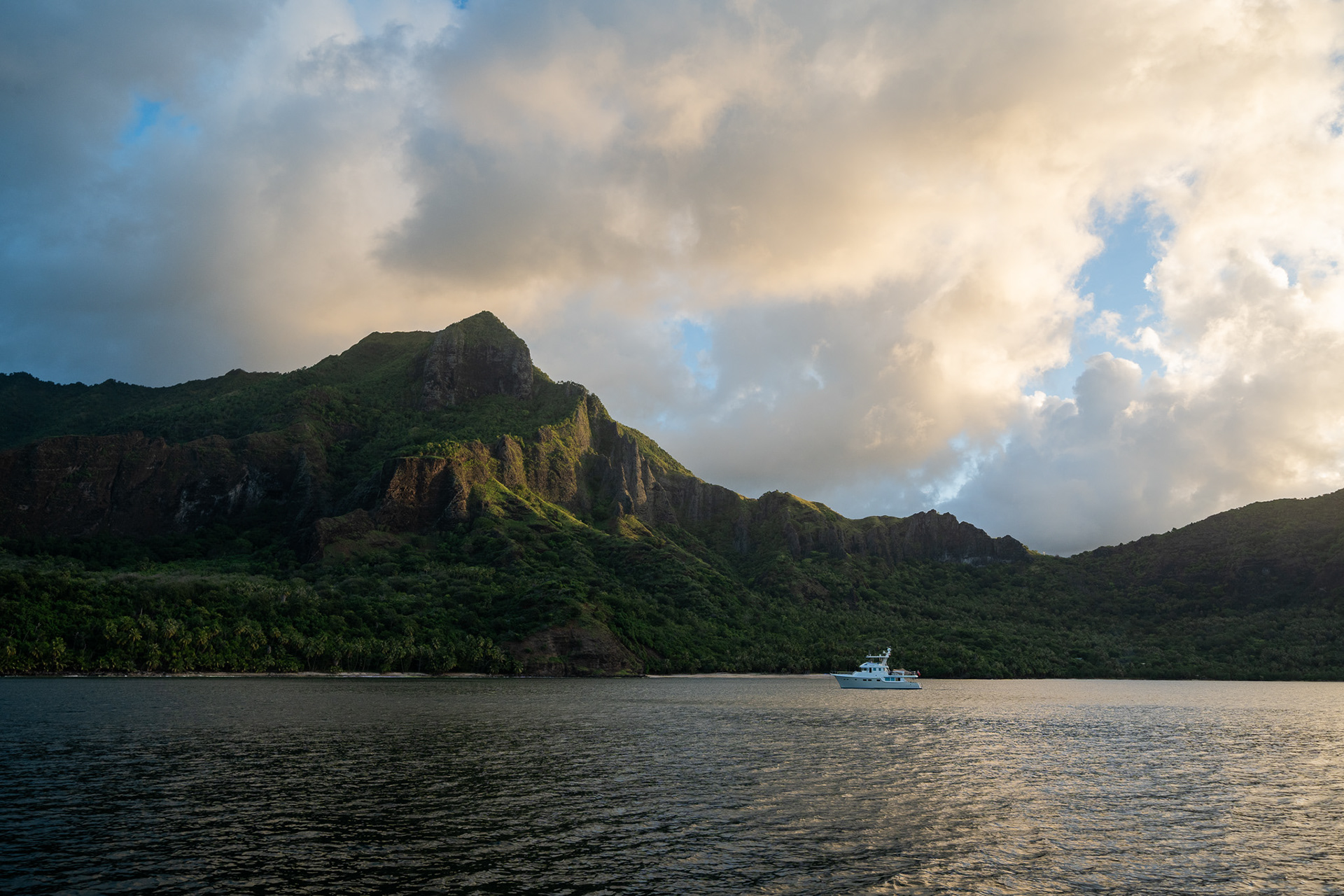 The setting sun casts a warm glow on the cliff side