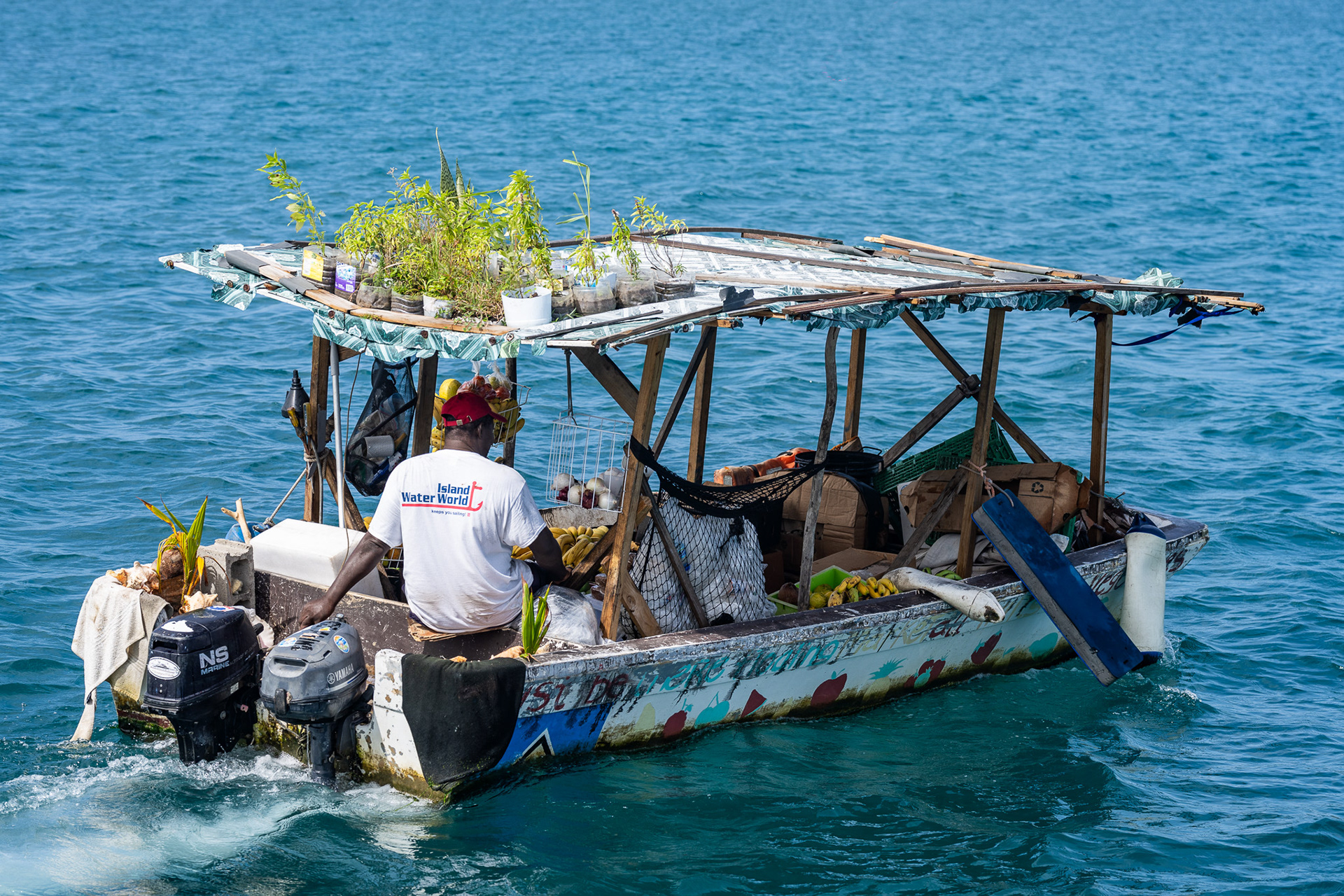 Putt-putting across Rodney Bay on his heavily loaded craft, Gregory visits passing boats peddling his goods including a plethora of local fruit, juices, and banana bread