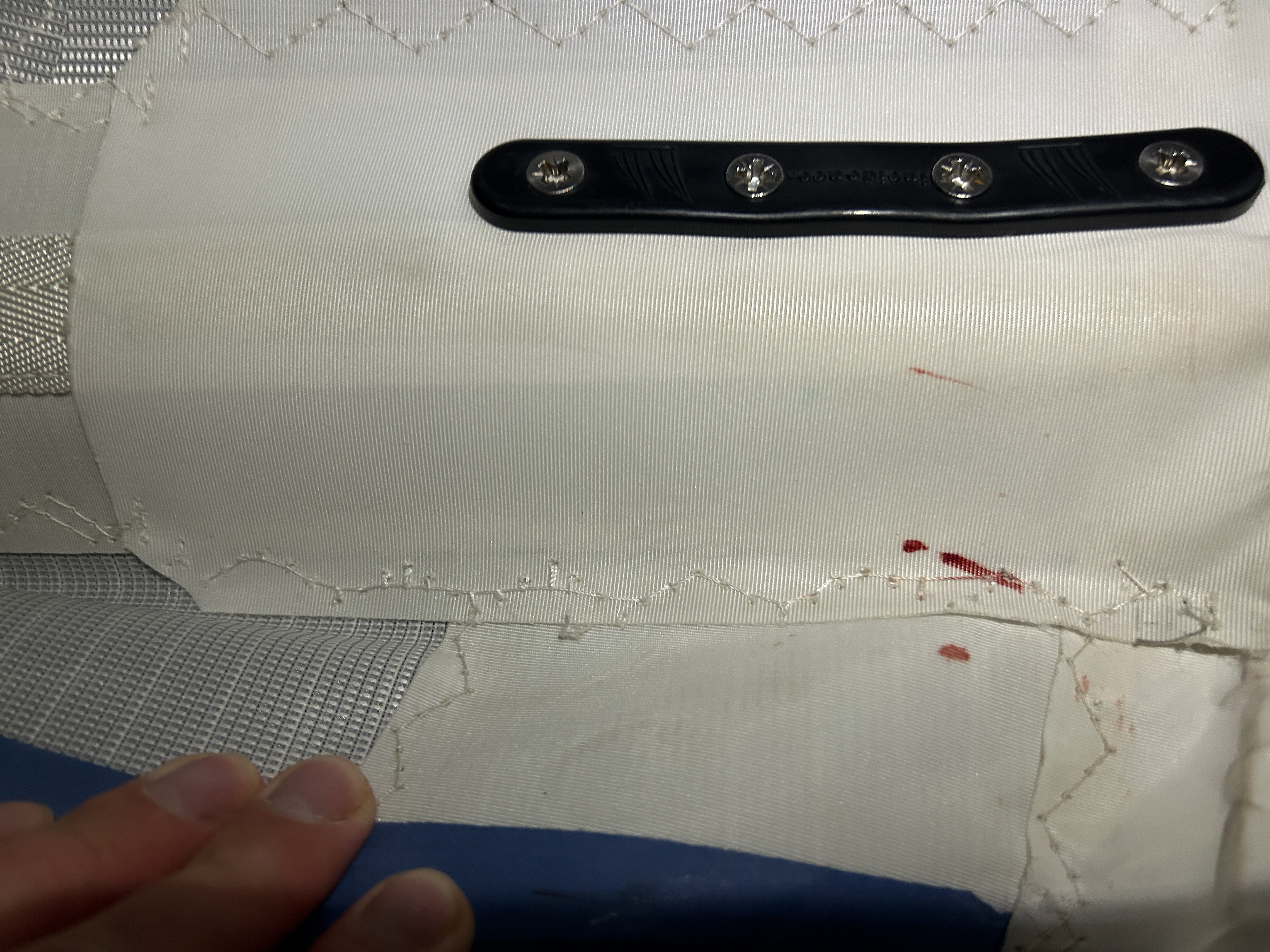Sewing up a torn batten pocket on the mainsail, one that cost me some blood