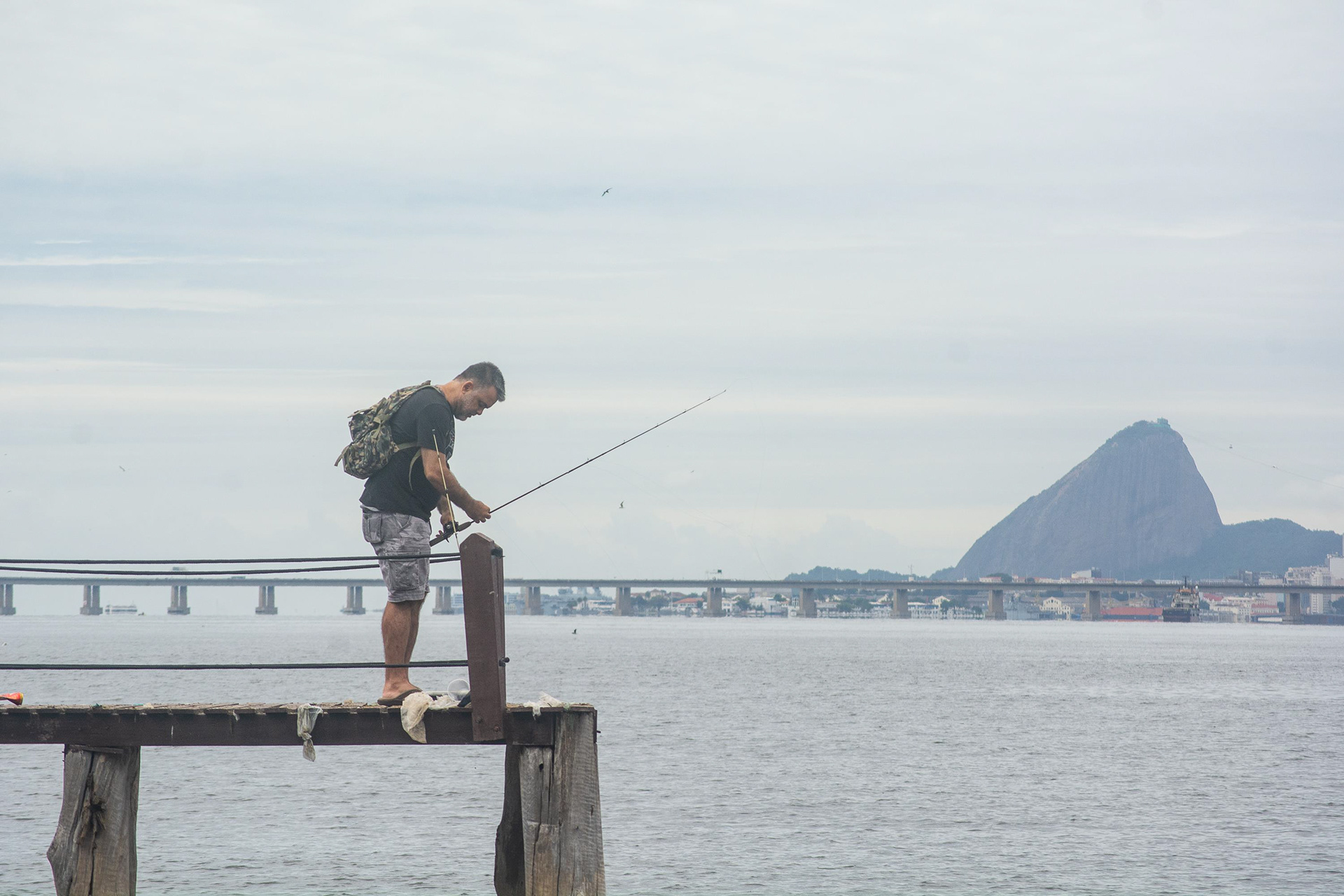 Homem pesca na Praia da Bica, na Ilha do Governador - Rio de Janeiro (RJ), 26 de novembro de 2023