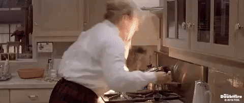 gif shows Robin Williams in a scene from the film "Mrs Doubtfire". While attempting to cook, his character accidentally catches the open flame on the chest prosthetics of his costume, and he's attempting to put out the resulting fire.