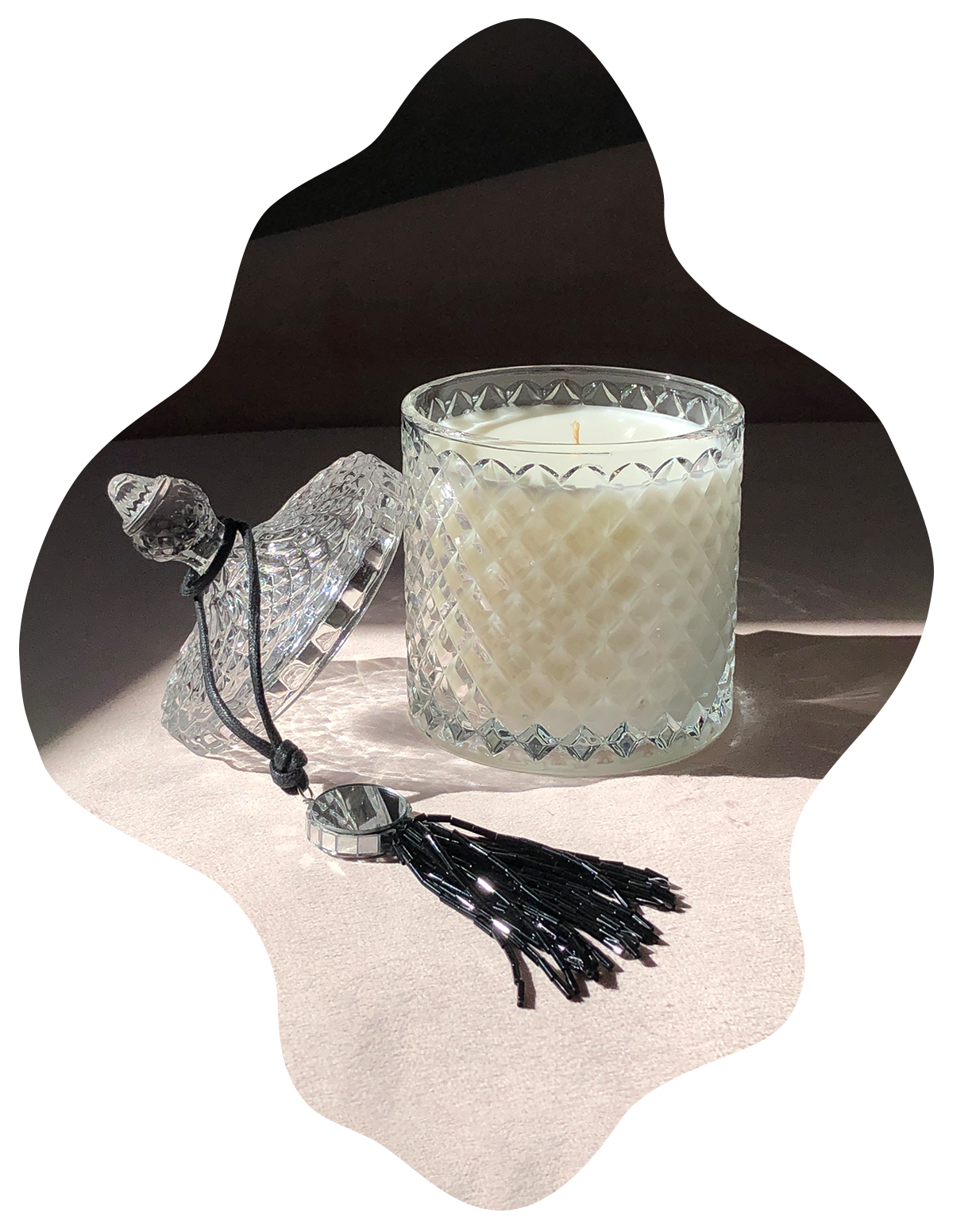 fancy glass candle with open lid and decorative beaded tassel