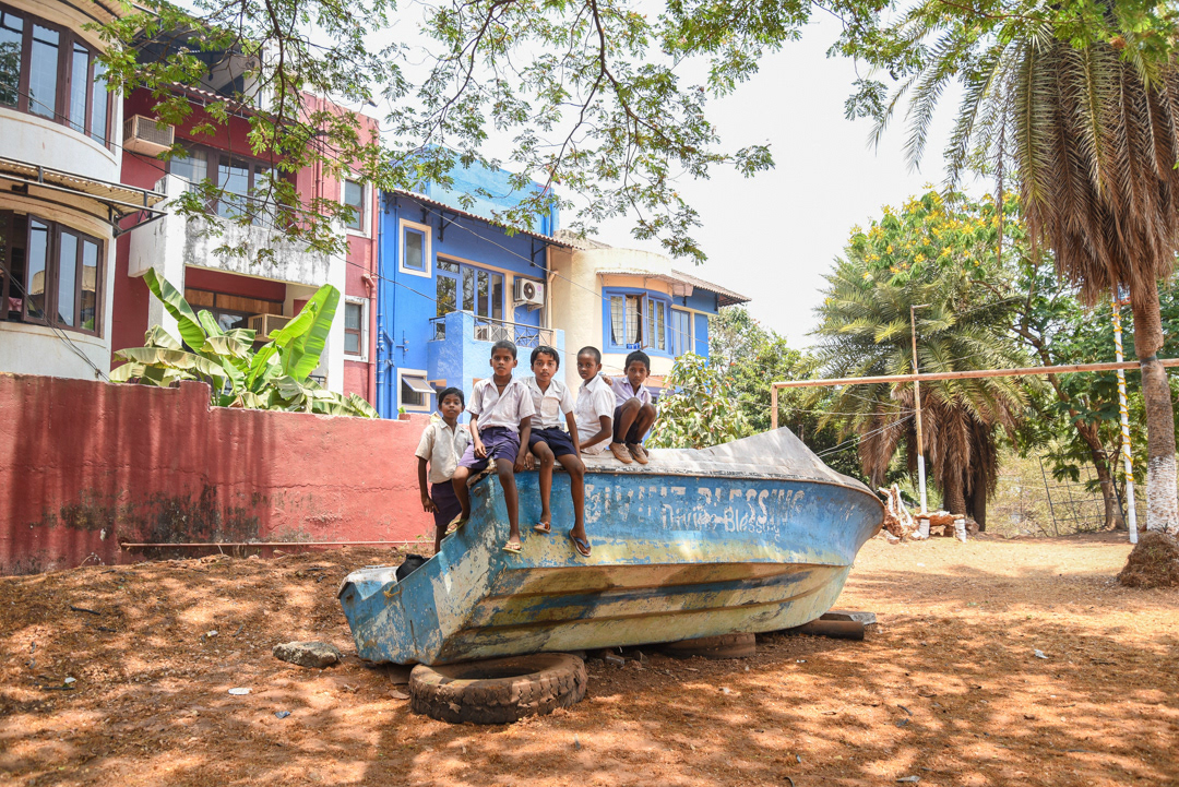 A group of 5 boys enjoyed posing for memorable photos around their public school playground.