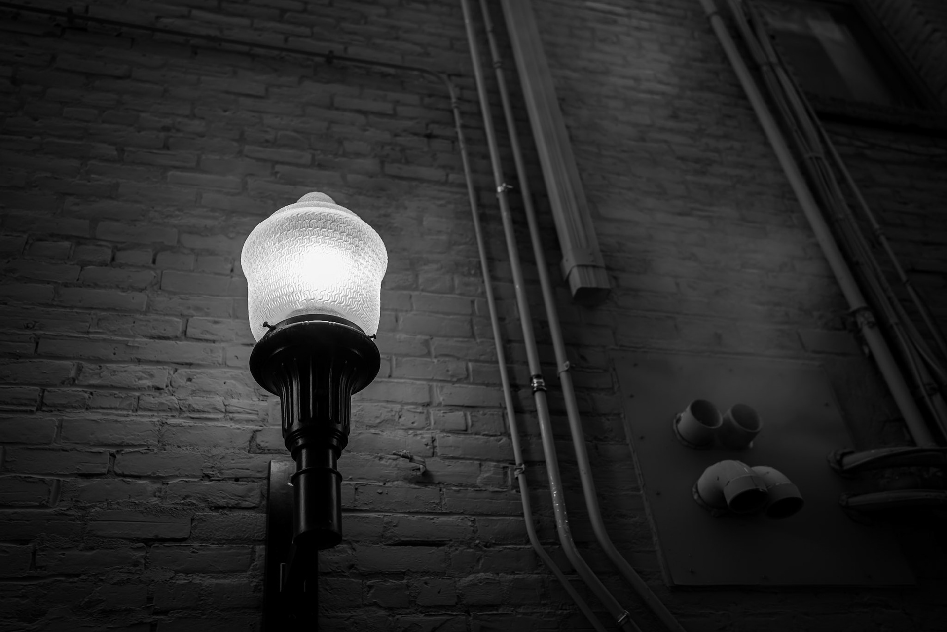 The alley lights still aglow as the vapor from a near by heating vent rises and dissipates into the ether.