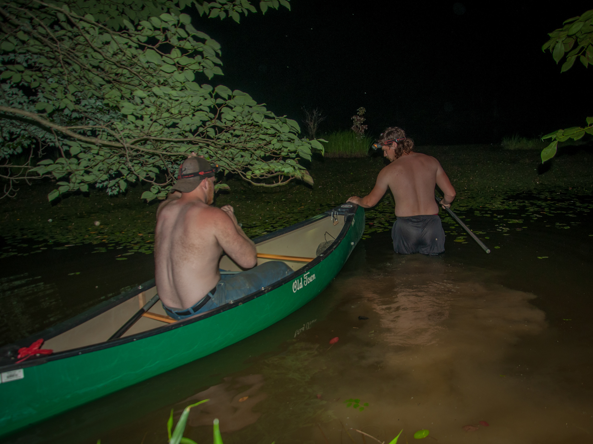 Wyatt leads a boat into the pond. He will wade along the boat for a while before hopping into it.