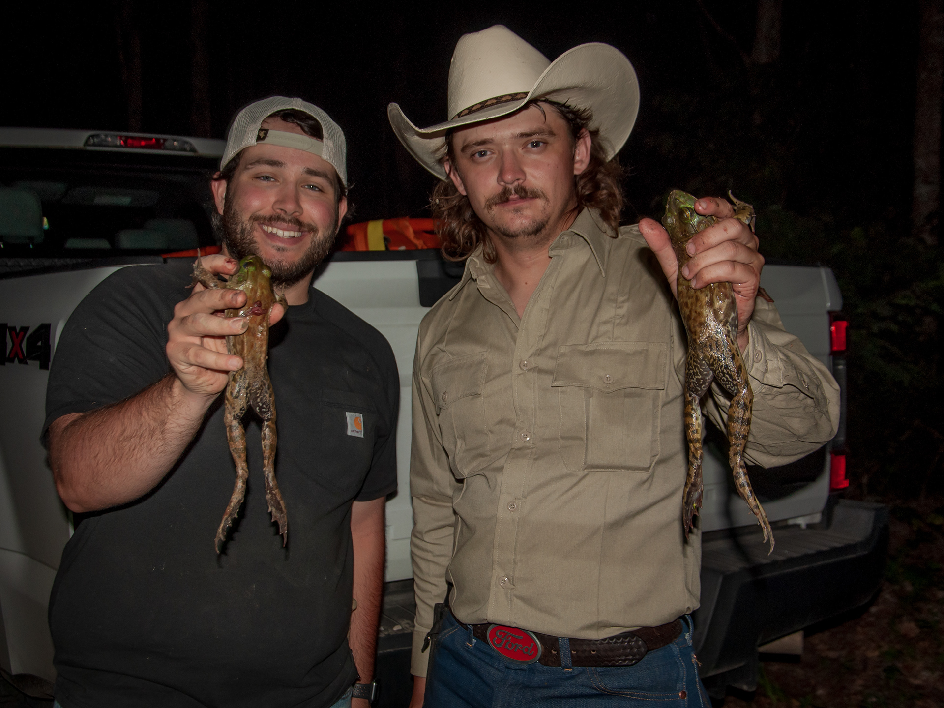 Giggers pose with large frogs that they collected during the gig.