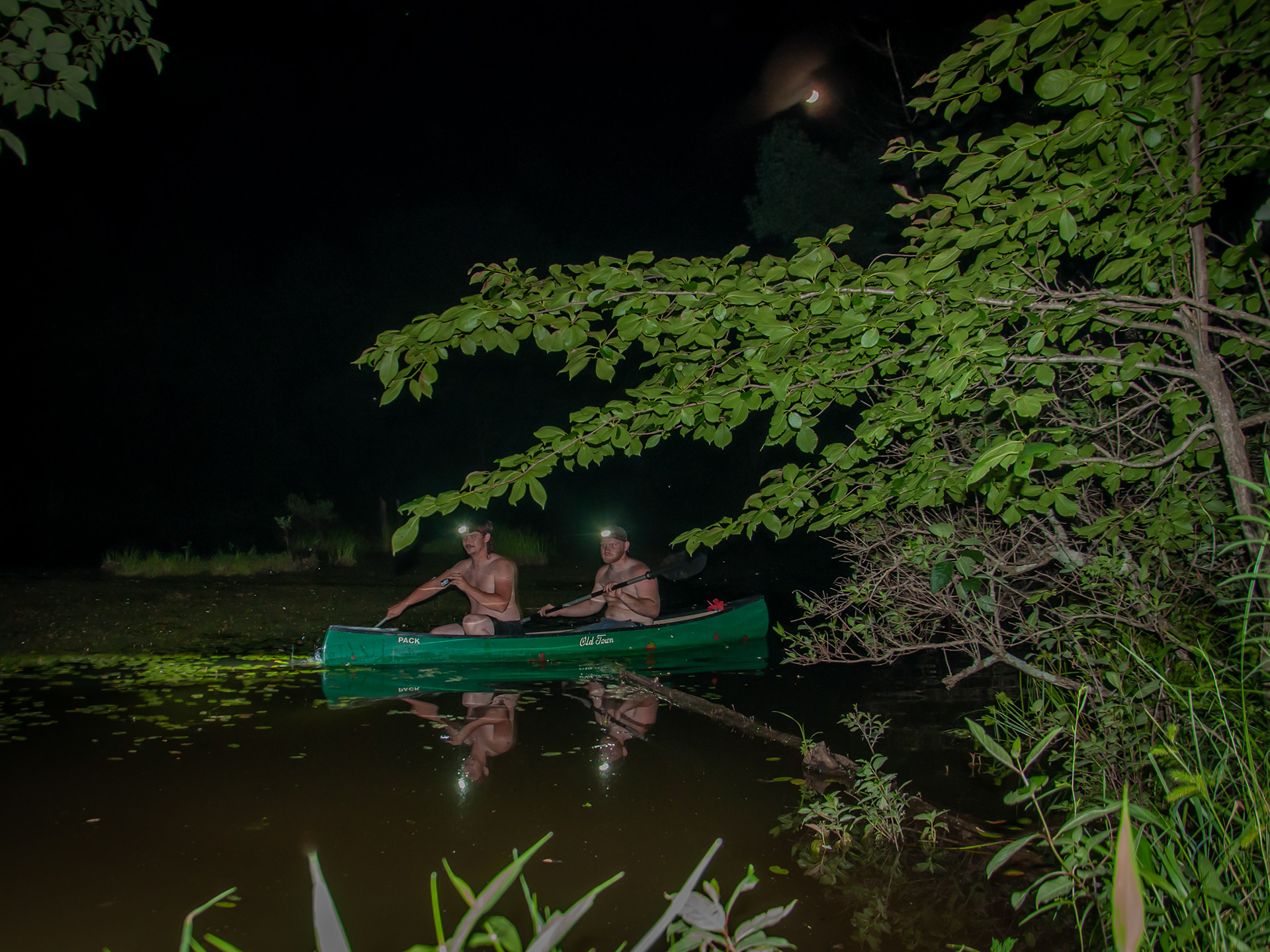 Hunters venture out into Cold Friday Pond to hunt the bigger frogs in the middle of the pond on a two person boat. The person sitting behind pilots the boat and the person forward directs and makes the hunt.