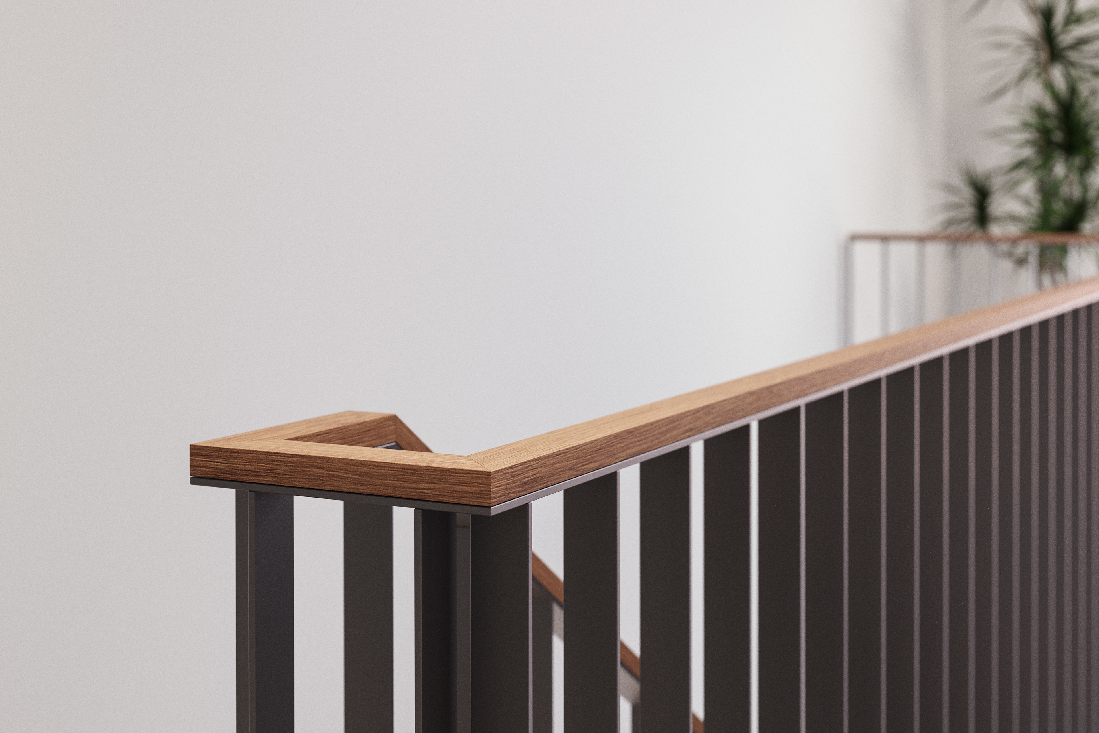 Nahaufnahme eines stilvollen Treppengeländers aus dunklem Metall mit elegantem, hölzernem Handlauf in einem zeitgenössischen Innenraum.