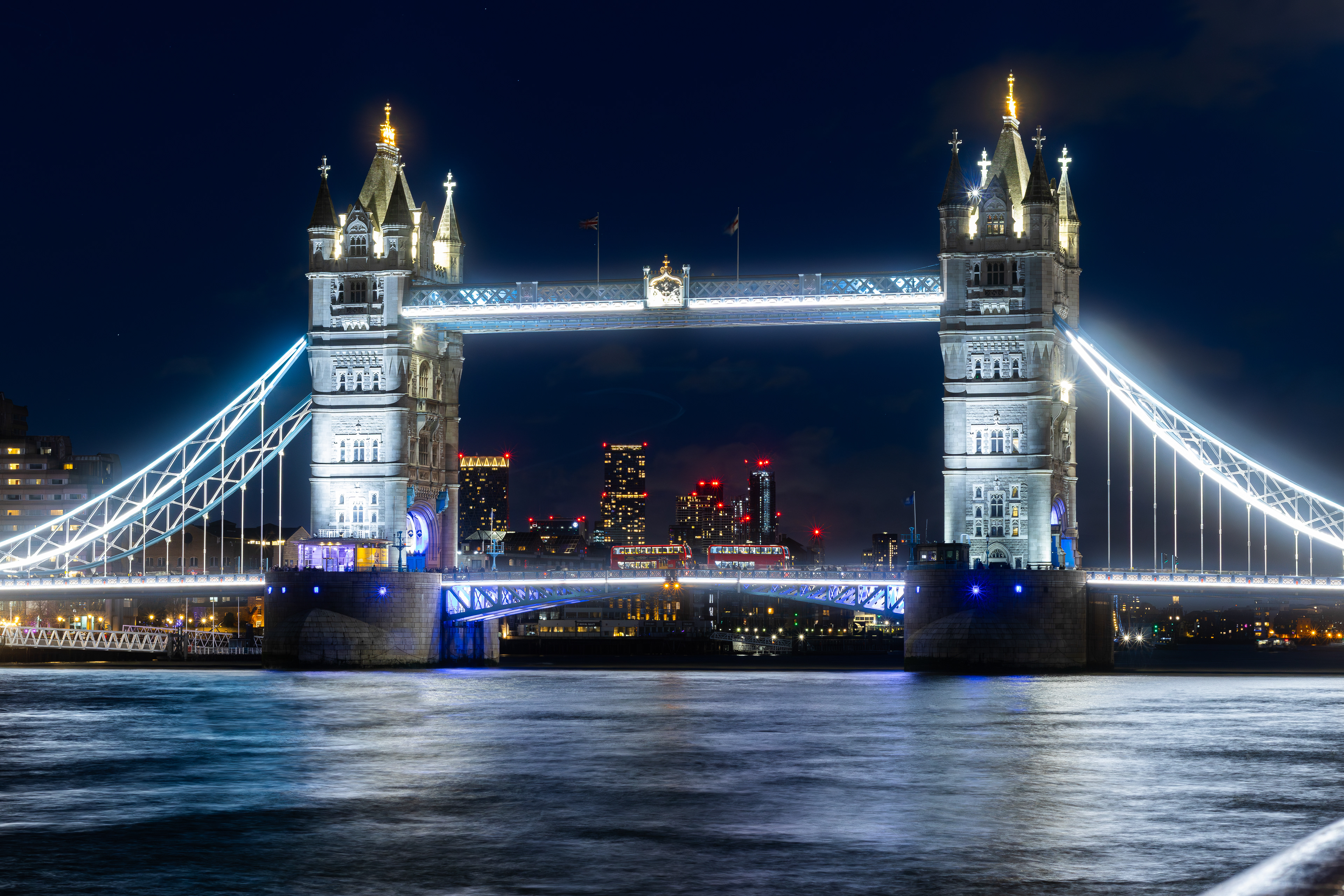 London, tower bridge lit up at night, two red buses
