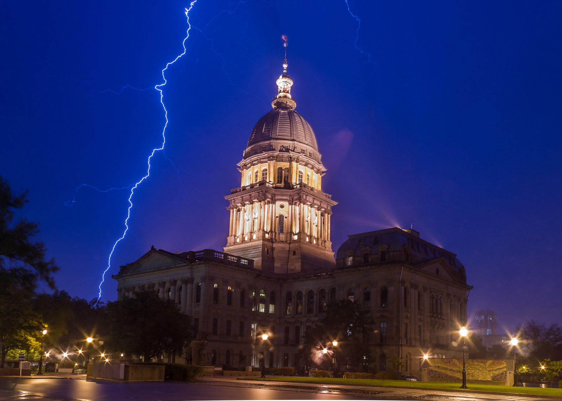 Lighting lights Capitol against blue night sky.