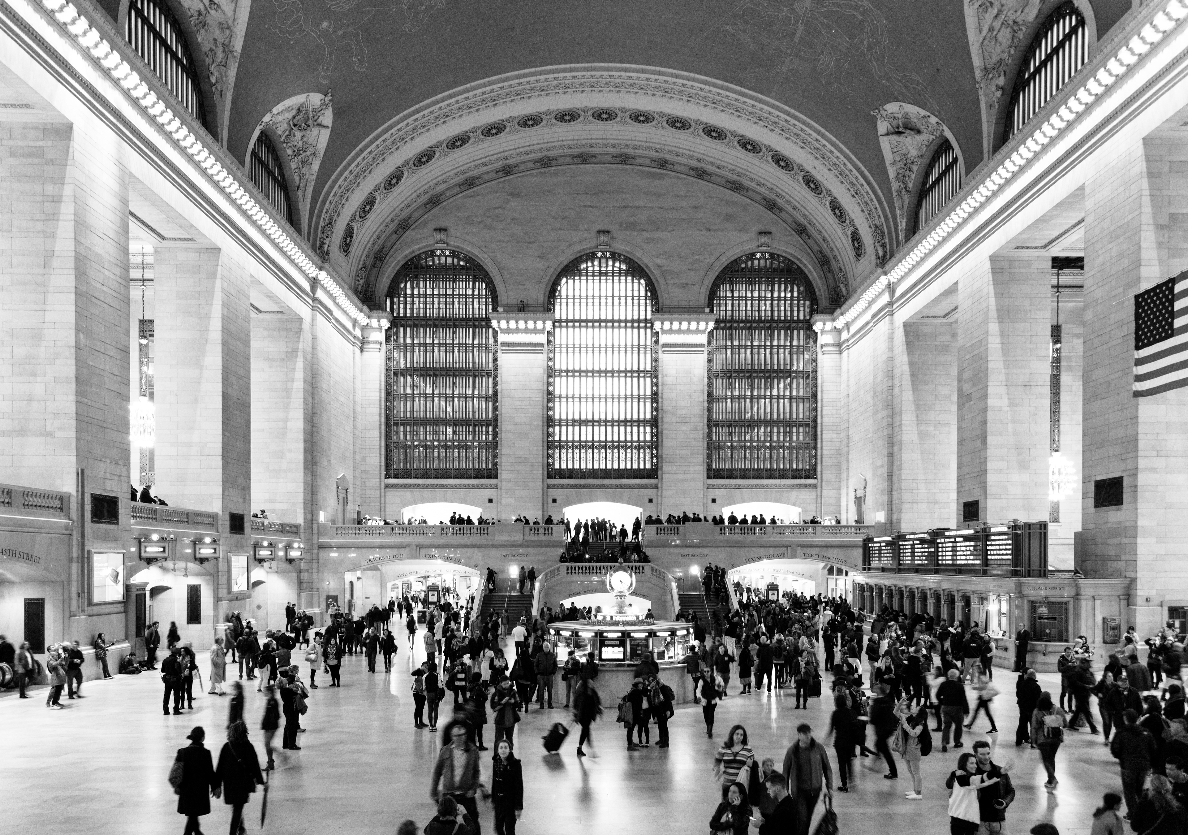 Looking inside of the Grand Central Station with People traveling to and from the trains.