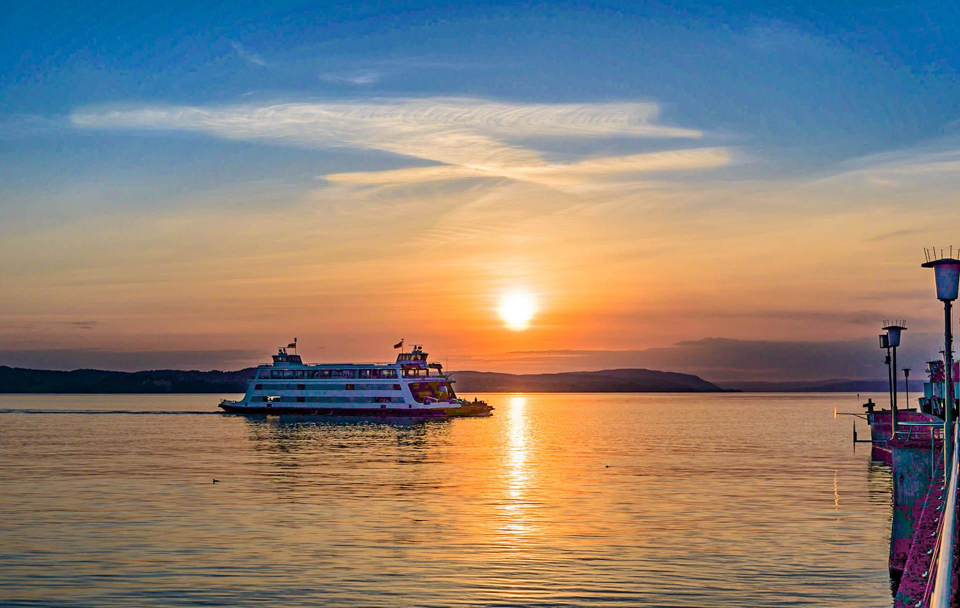 Ferry boat "Kreuzlingen" closing in on the harbour of Meersburg at sunset.
