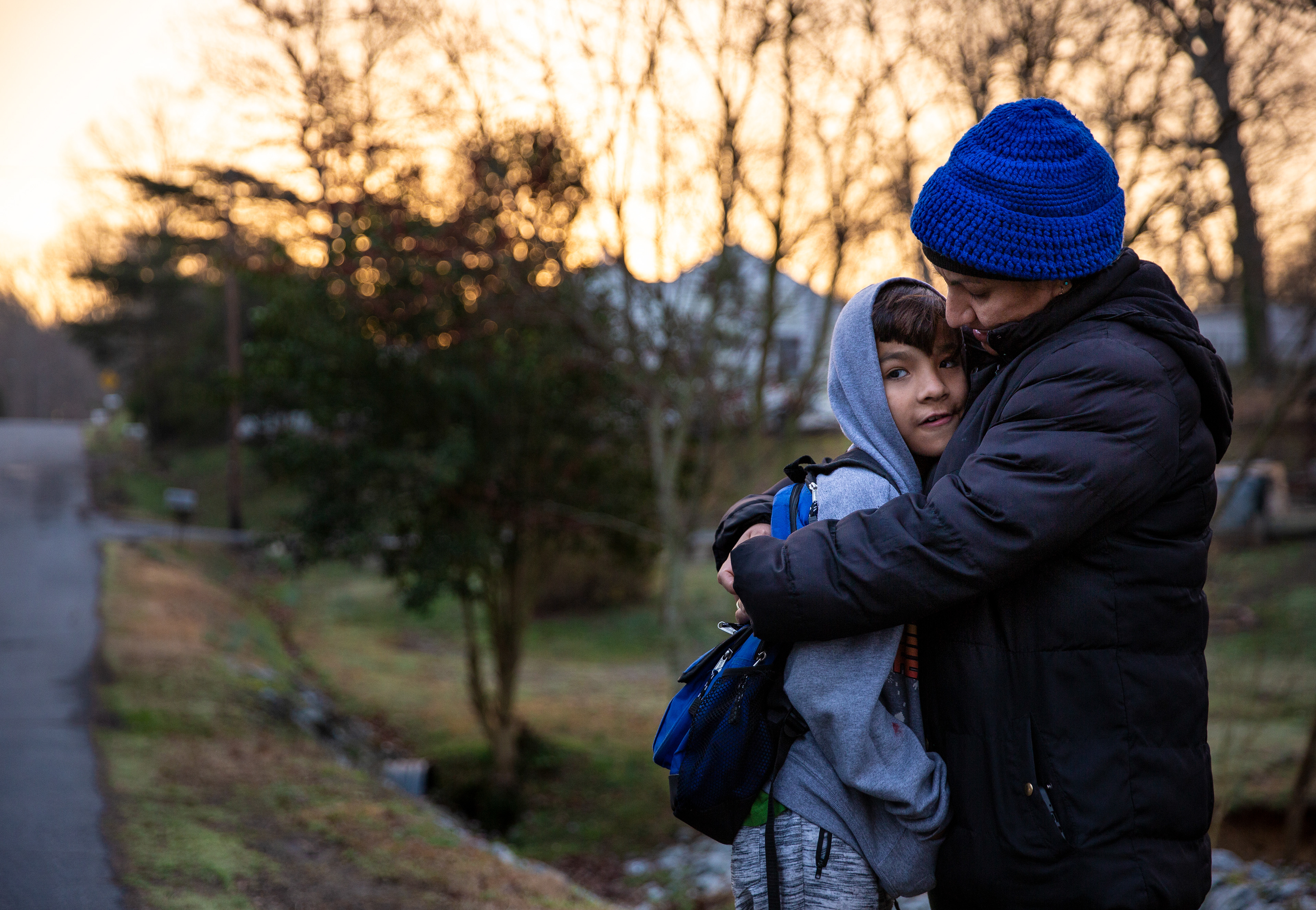 Maria Lina Curiel, right, embraces her son, Brandon, while waiting for the school bus early one morning in Asheboro, N.C.