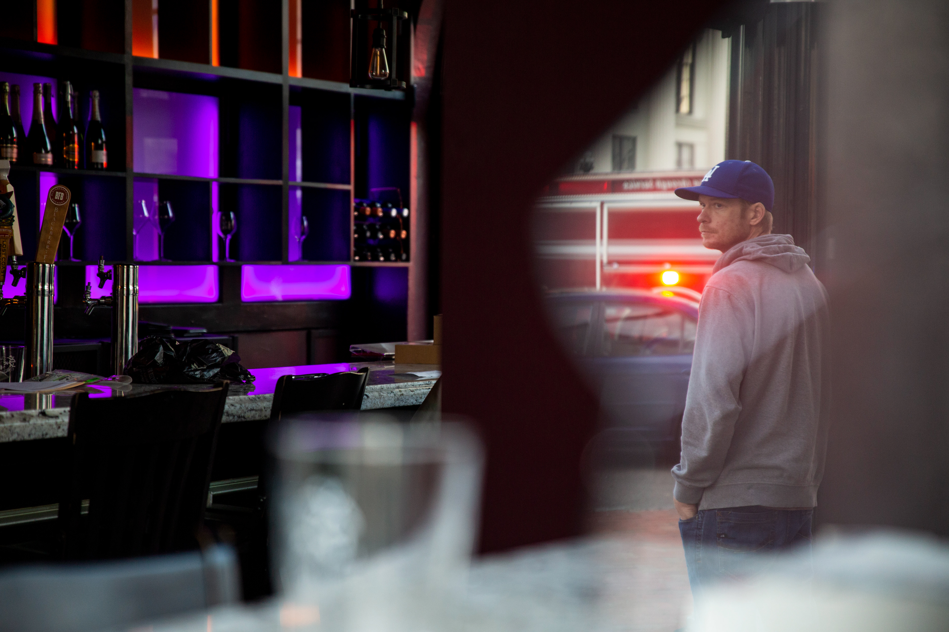 The driver of the vehicle that struck a streetlight is seen reflected in a window that was broken during a two car accident on the corner of 3rd and Princess Street on Monday, March 18, 2019. 