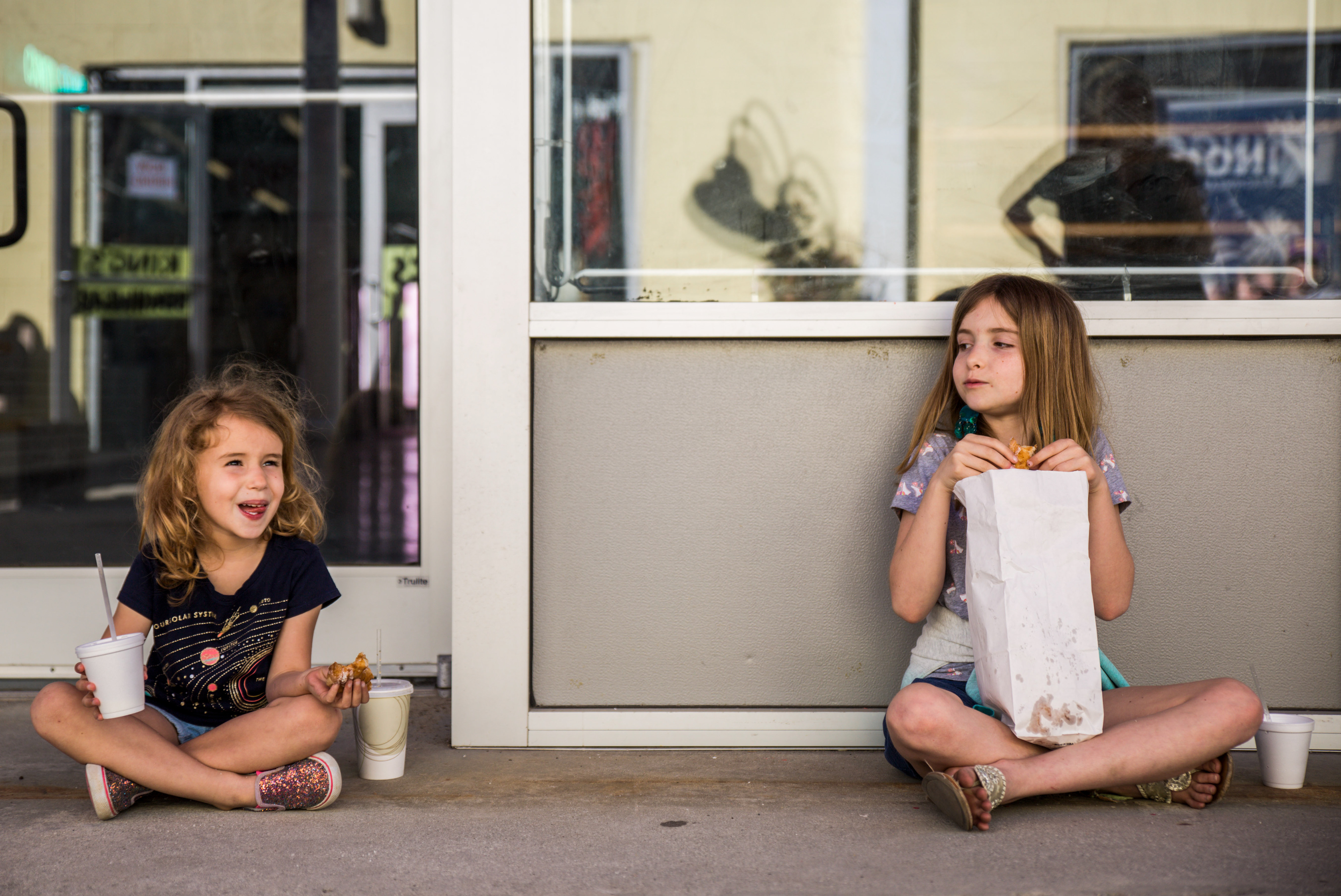 Violet Burch, 5, left, and her sister, Maya, 8, enjoy fresh donuts on opening day at Britts Donuts on Friday, March 29, 2019 in Carolina Beach, N.C.
