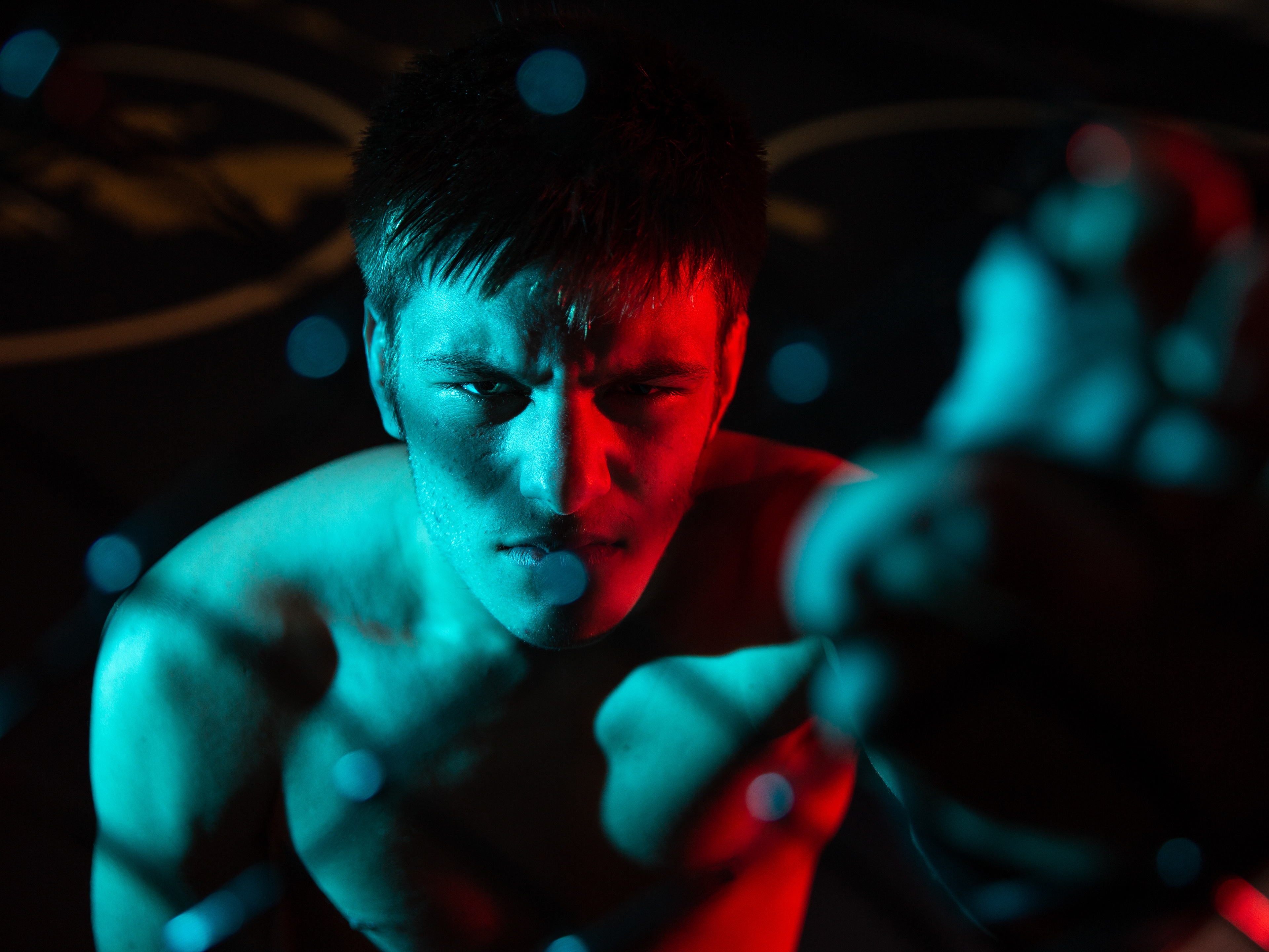 Wyatt Joyce looks through the chainlink of the fighting cage at the Asheboro School of Martial Arts in Asheboro, N.C.  Joyce started boxing one month after his brother passed away in 2017, and soon after competed in his first fight, which he won.
