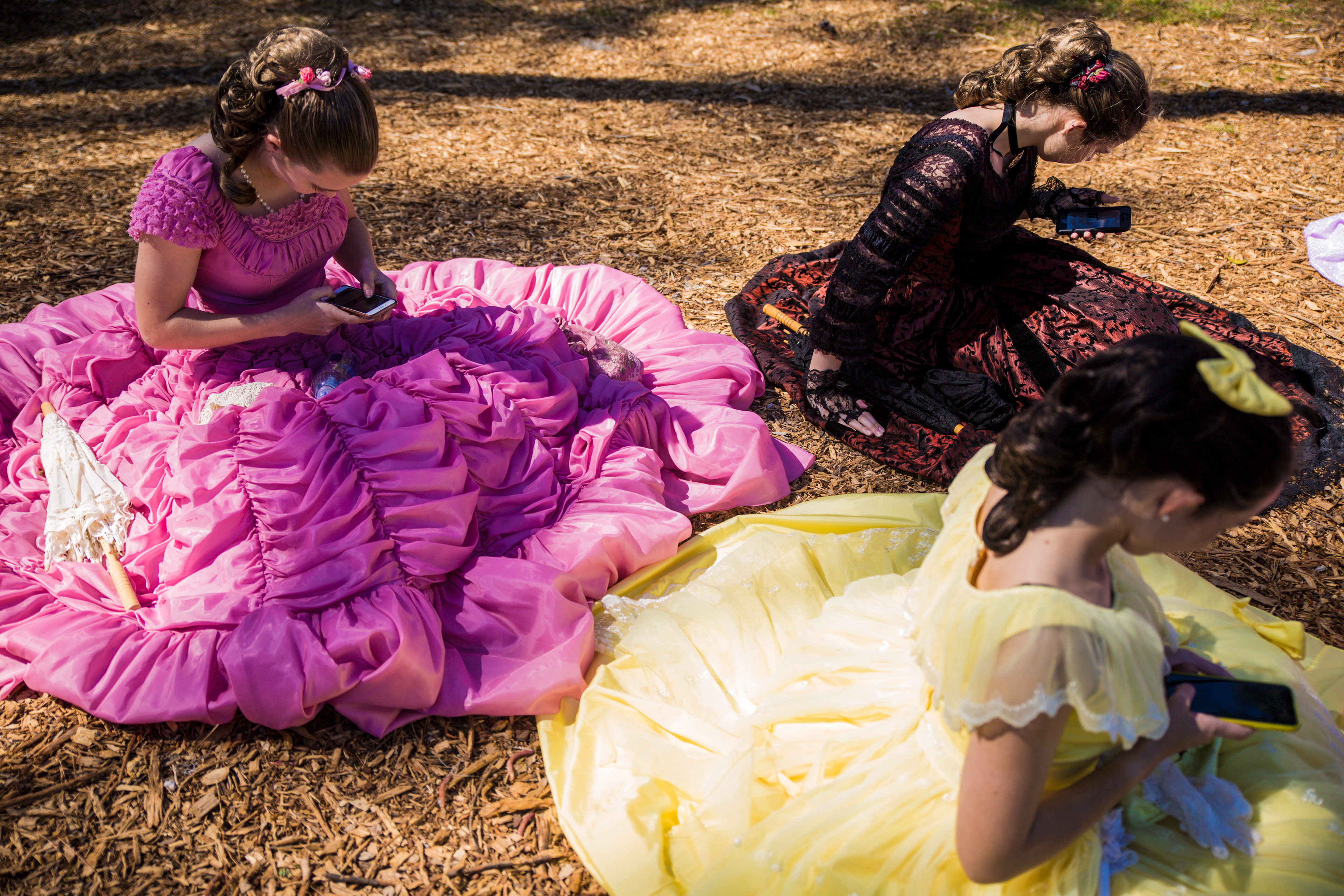 Cape Fear Garden Club Azalea Belles check their phones during a break at the Queen's Coronation during the 72nd North Carolina Azalea Festival at Greenfield Lake Amphitheatre in Wilmington, N.C., on Wednesday, April 3, 2019.